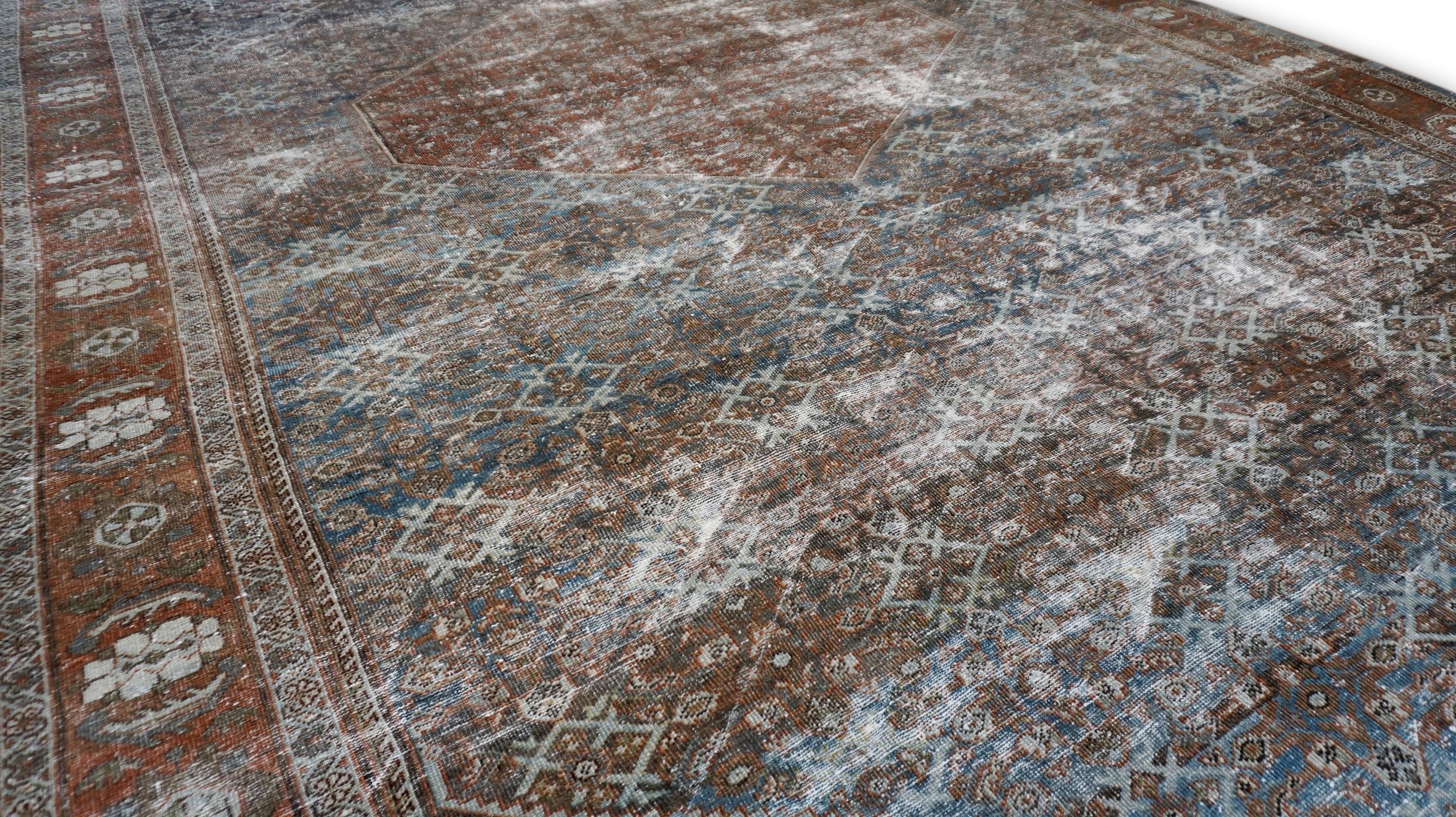 Dieser exquisite, handgeknüpfte antike Wollteppich zeigt ein zeitloses Medaillon-Design, das reich an traditioneller Kunstfertigkeit und Handwerkskunst ist. Dieser große Teppich wurde in Persien aus handgesponnener Wolle gewebt und weist ein