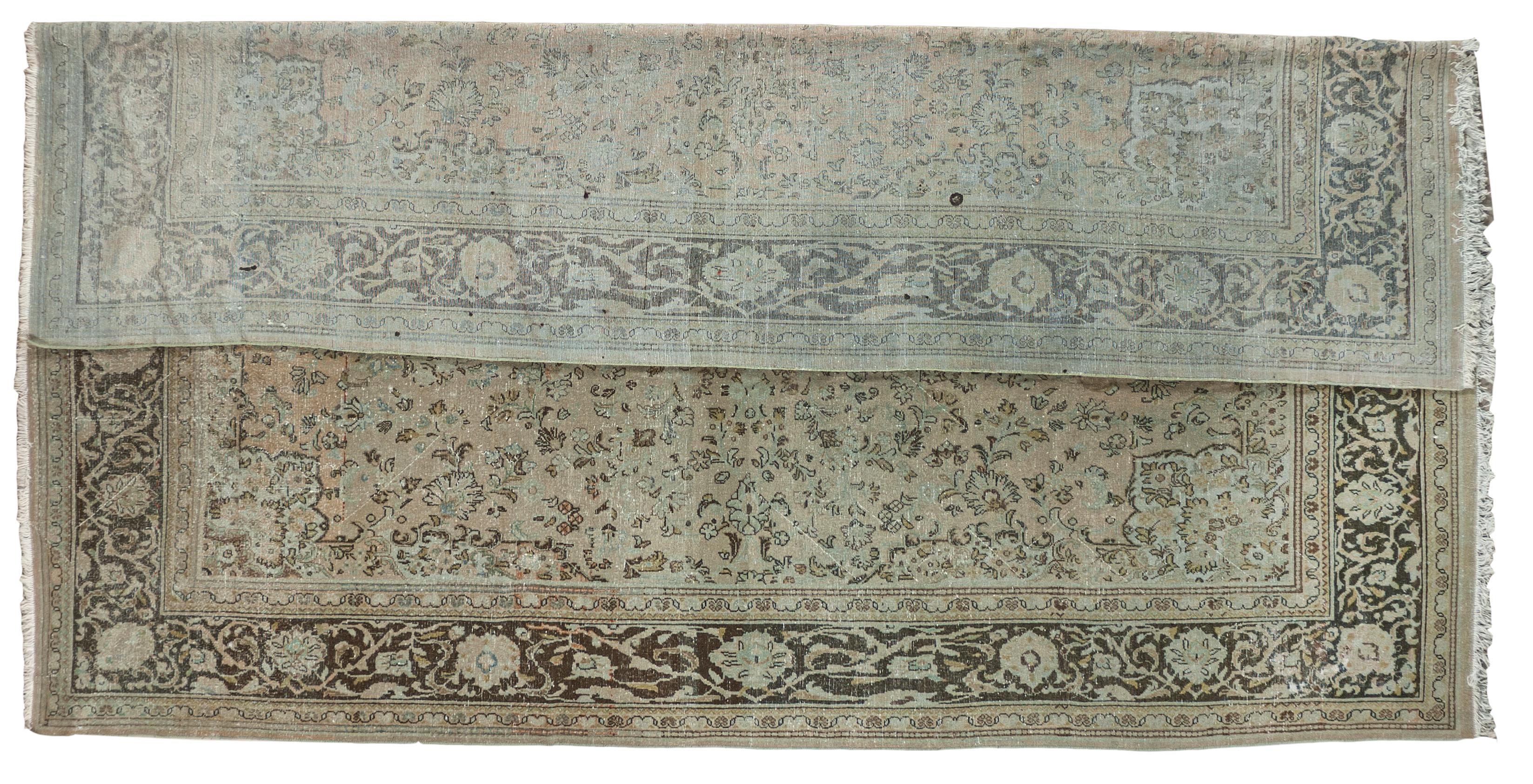 This antique distressed mahal is an all wool Handmade and Hand knotted rug. This distinctive area rug that has a center medallion and wide stylized floral frame is from the 20th century and was made in Iran. The name is derived from the Mahallat