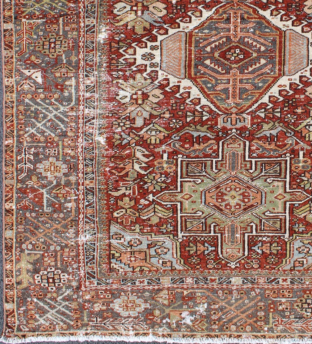 Tapis persan antique Heriz en détresse avec trois médaillons à motifs géométriques tribaux, tapis GNG-4771, pays d'origine / type : Iran / Heriz, vers 1920.

Ce tapis persan Heriz ancien, tissé à la main au début du XXe siècle, présente un champ