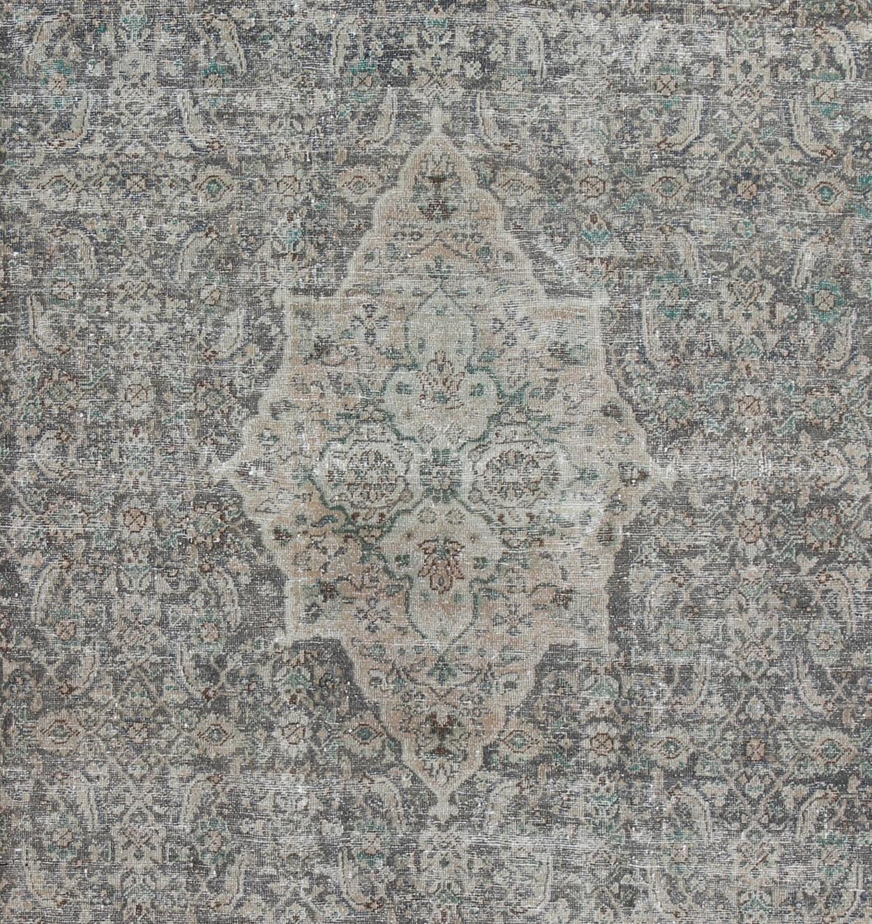 Measures: 10'5 x 13'4

This antique Persian Mahal rug with an understated medallion design has been distressed and features a unique color combination with soft gray, taupe, green, light brown accents and blush/pink border.

Country of Origin: