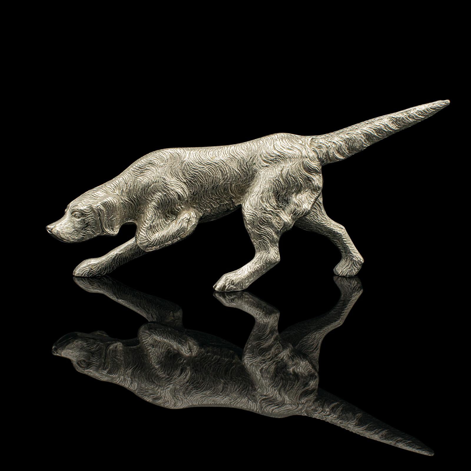 
This is an antique dog figure. An English, nickelled cast iron pointer hound ornament, dating to the Edwardian period, circa 1910.

Striking a superb field pose, typical of the breed
Displays a desirable aged patina and in good order
Tactile