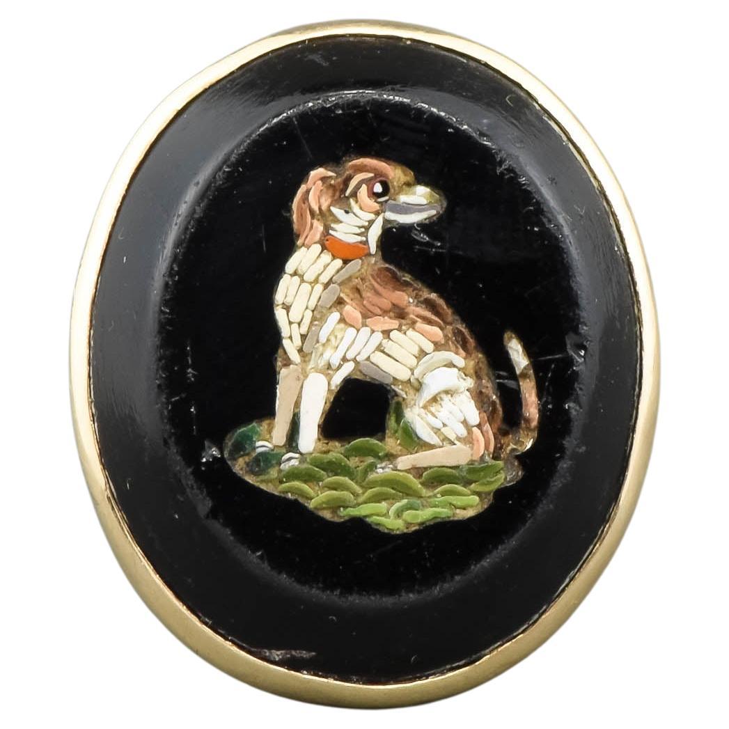 A charming, somewhat rustic and worn, Victorian micromosaic Dog ring to keep you company.  

Crafted of yellow gold testing around 12K, the ring features a sweet Spaniel type of Dog depicted in micro mosaic form within a large oval shaped glass