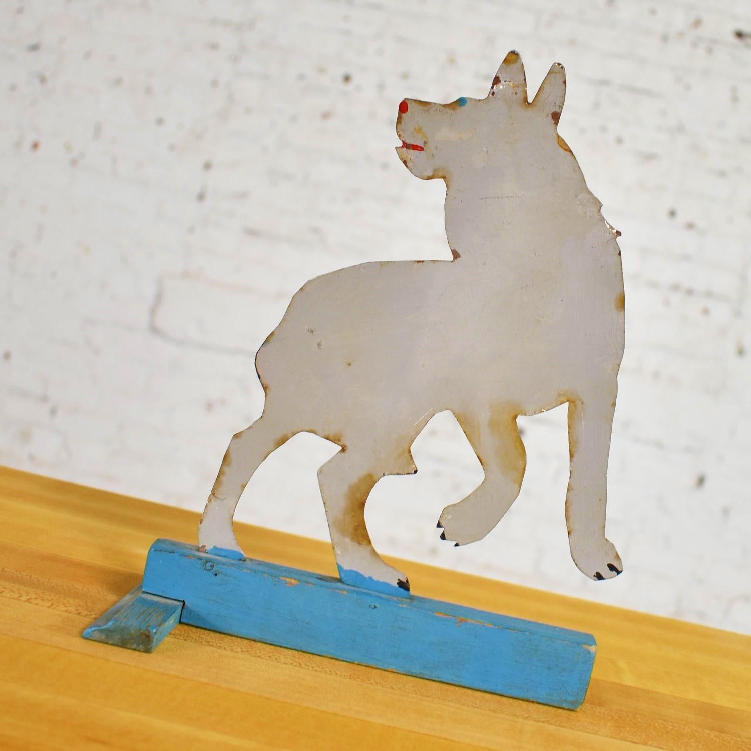 Incredible antique Folk Art tin cutout sculpture of a dog or a wolf. It is hand painted and on a painted wood T-shaped base. It is in wonderful vintage condition with lots of great patina including rust and chipping paint. Please see photos, circa
