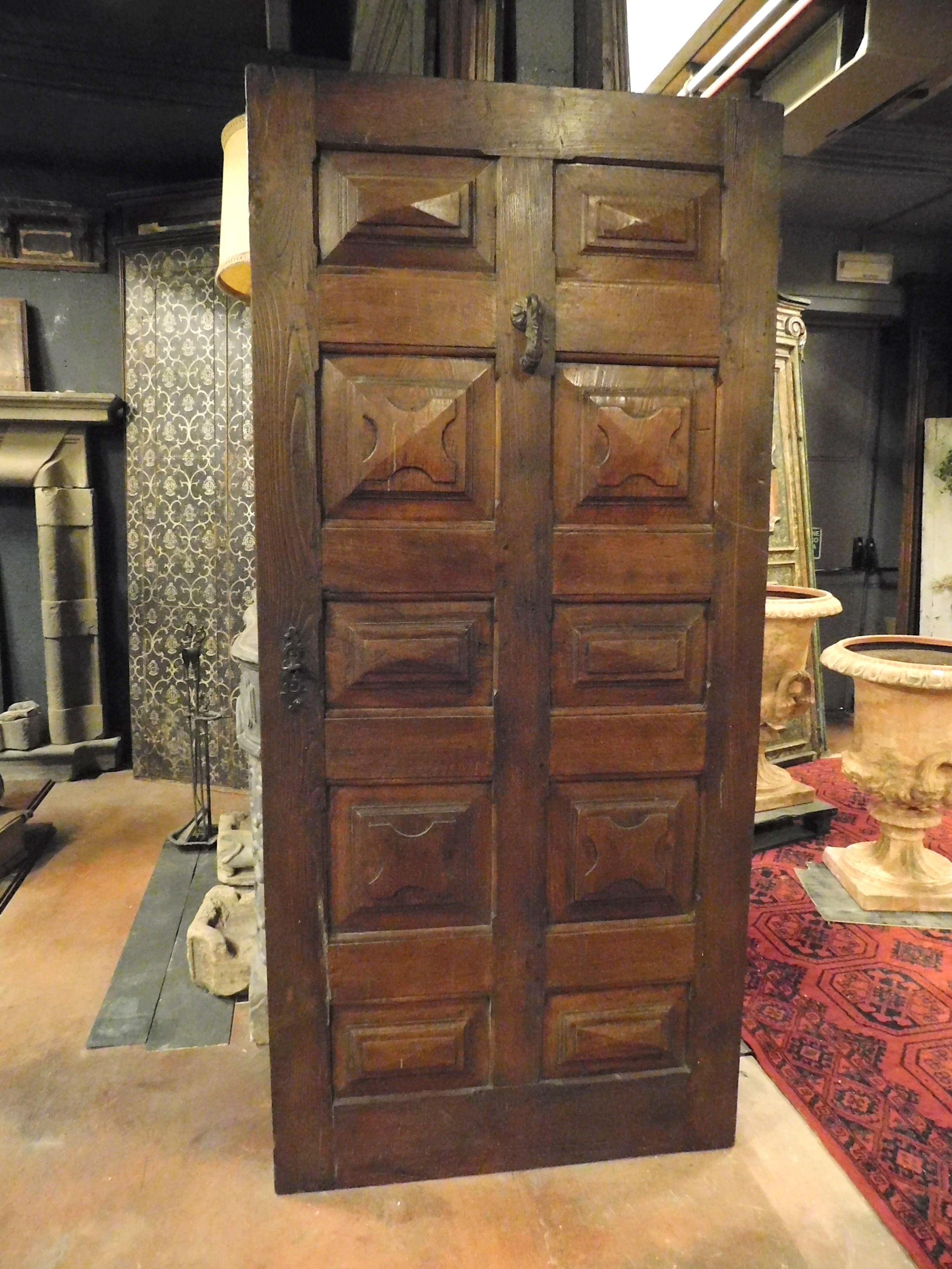 Antique door in precious solid walnut wood, with many hand-carved panels with a jutting diamond shape, built entirely by hand in the 17th century for an important building in Italy,
Very fascinating, it retains the patina of the centuries that made