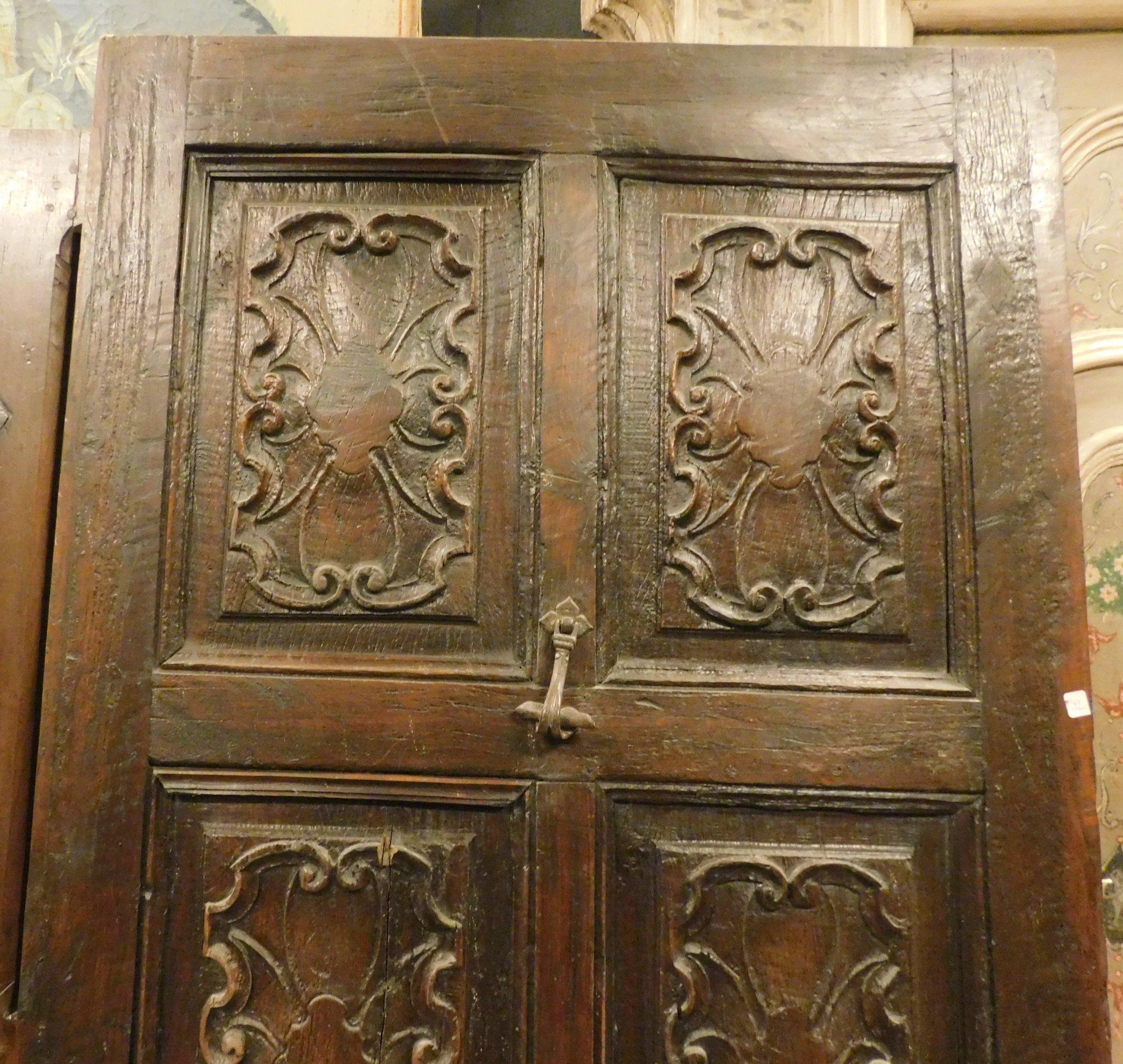 Ancient entrance door, in fine hand-carved walnut, very rich and carved panels with very Italian motifs such as cobweb. It comes from an important palace in northern Italy, dating back to the 17th century, which belonged to a rich man in the