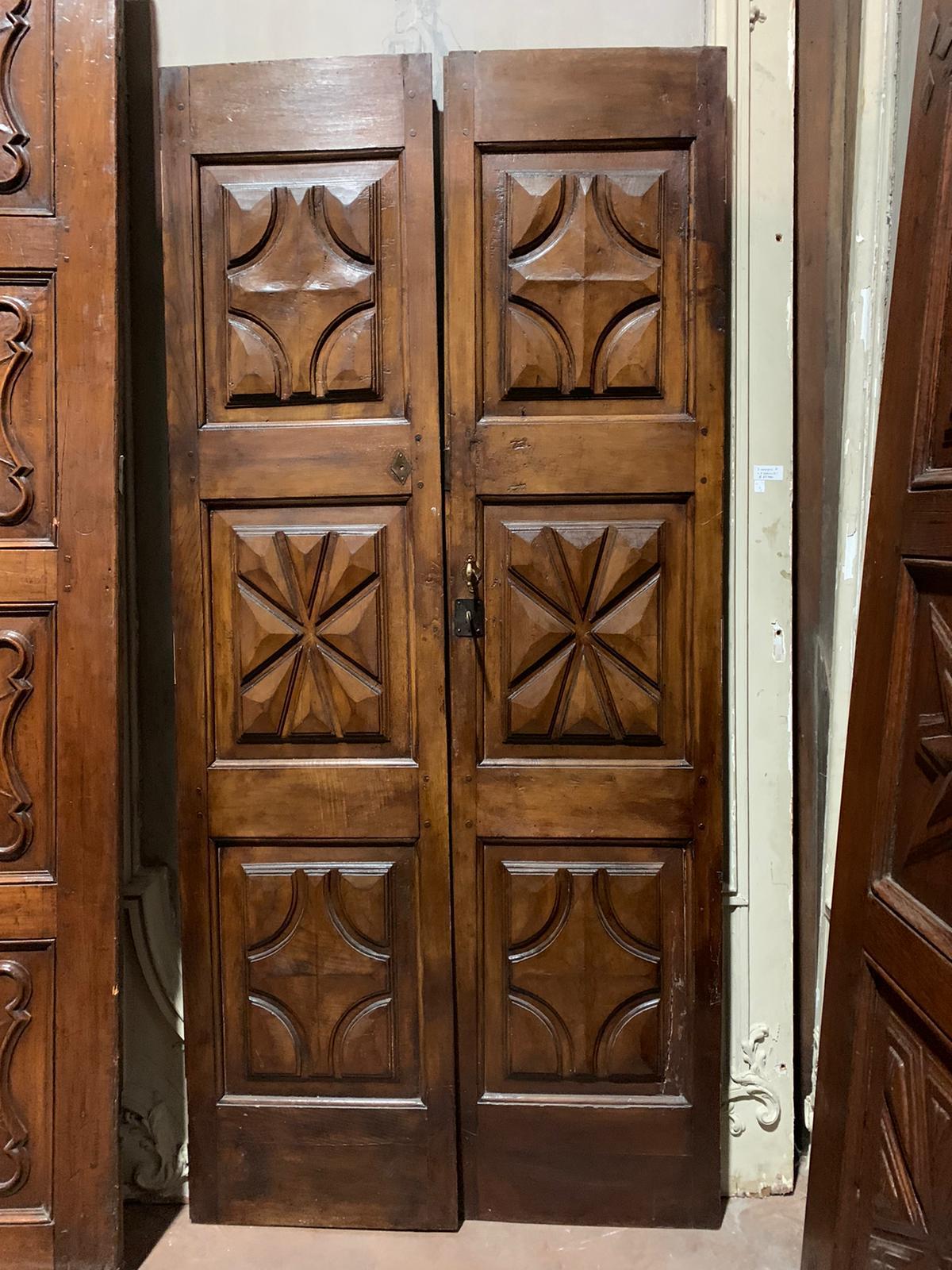 Important and very Antique double-wing interior door (or entrance door), entirely hand-carved in precious solid wood, patinated and beautiful brown, precious walnut wood, very deep carved shapes (sign of great value of the commission) with diamonds