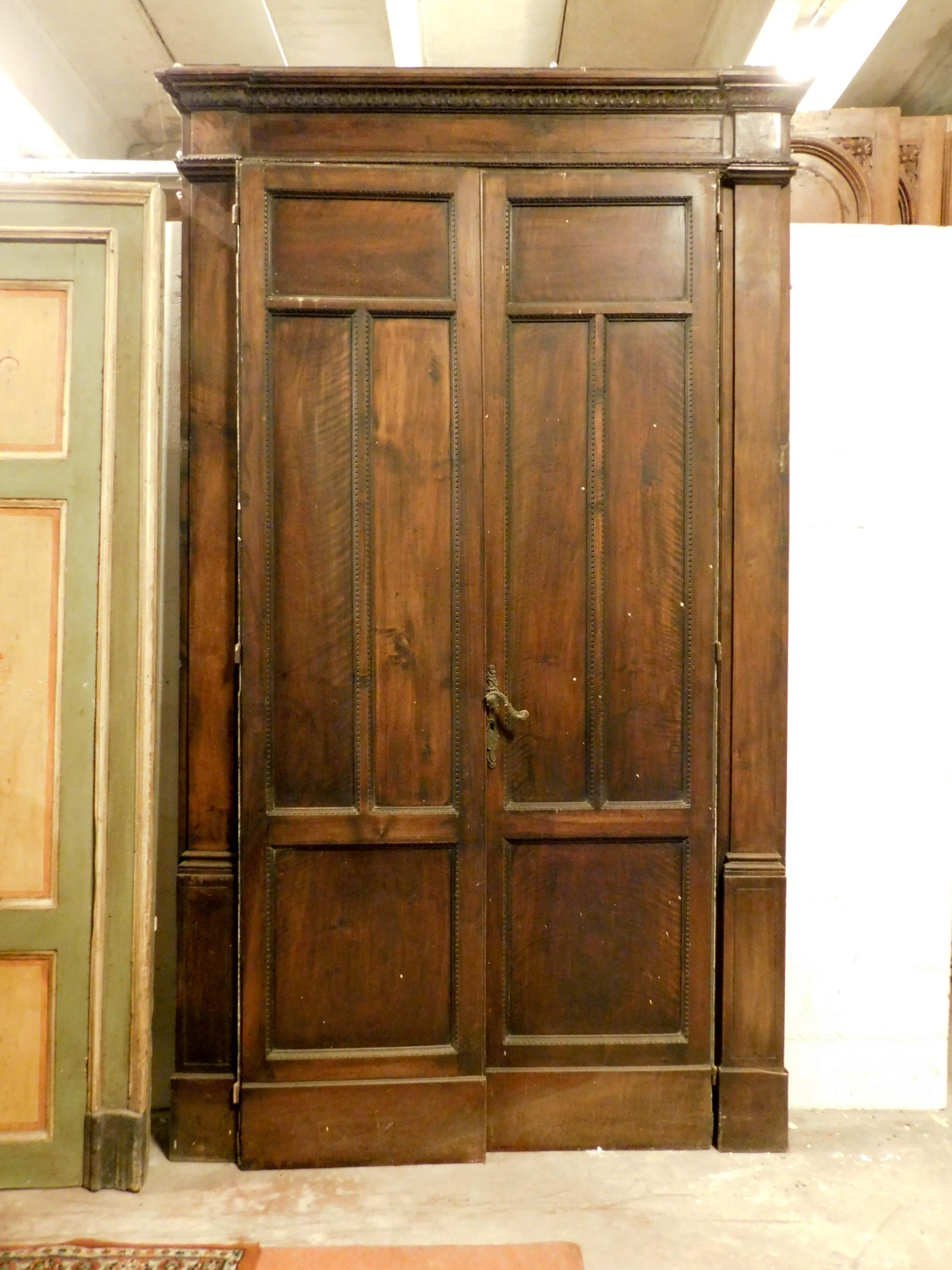 Antike zweiflügelige Tür, geschnitzt in Nussbaum und komplett mit Rahmen, handgefertigt im ersten Viertel des 20. Jahrhunderts, aus Turin (Italien), maximale Größe 158 x 273 cm, Türbreite 123 x 249 cm.
Schön und imposant, trennte es einen Raum von