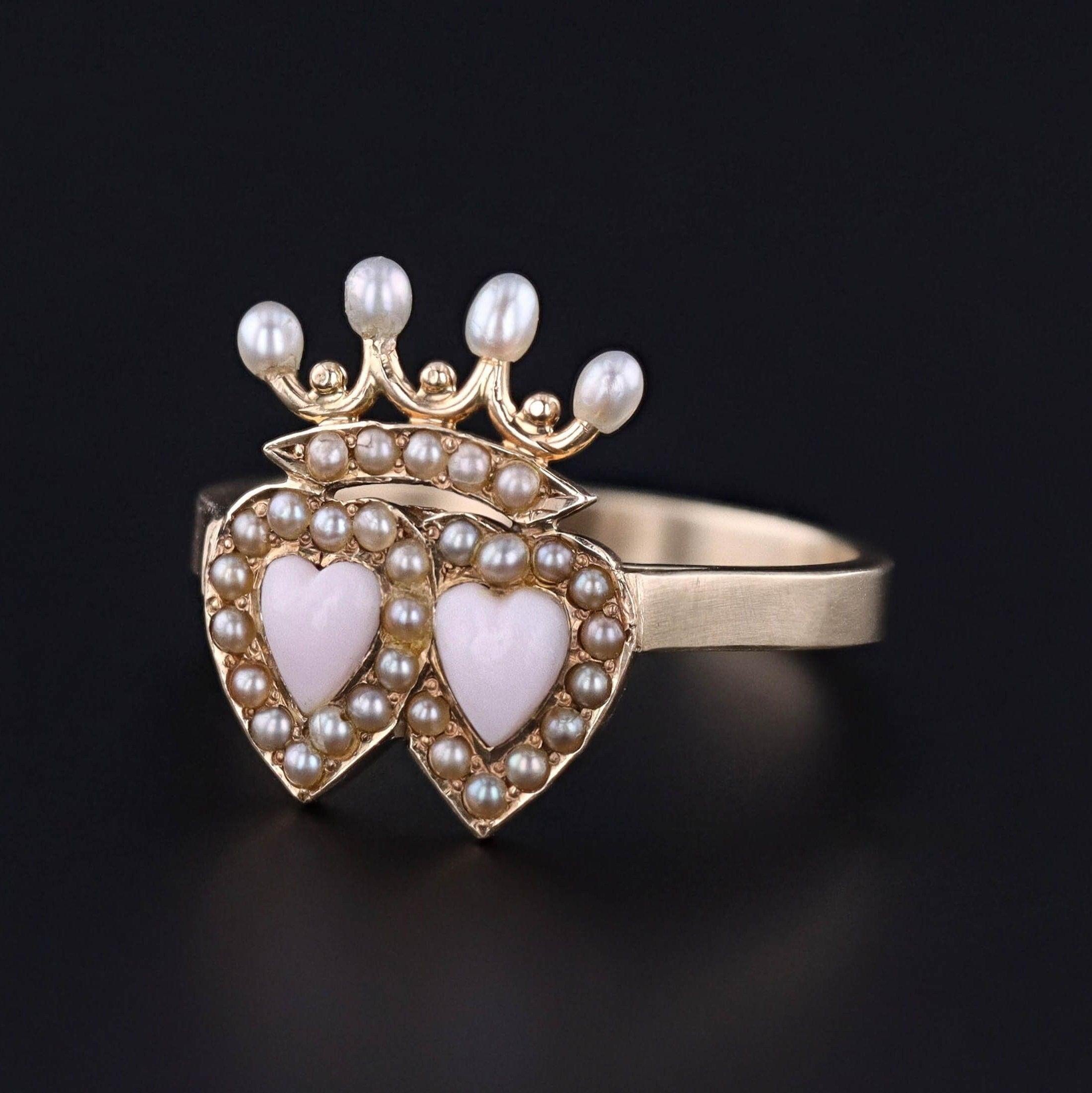 A fabulous love token ring featuring two hearts beneath a crown.

The face of this gorgeous ring was originally an antique stickpin (circa 1880-1900) transformed with a newly made custom 14k gold mounting.

The hearts are a pink hued coral framed by