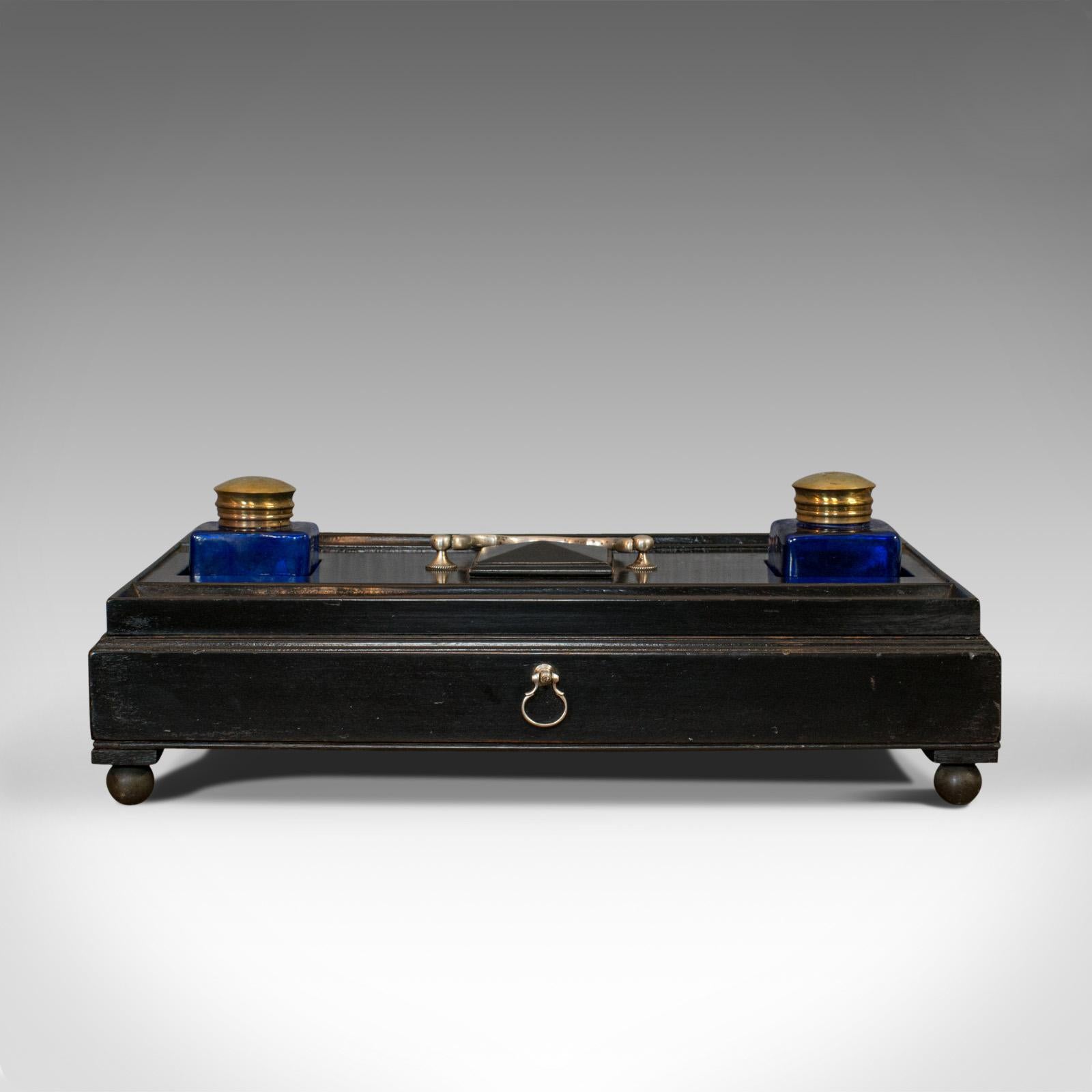 This is an antique double ink well. An English, ebonized mahogany desk tidy from the Aesthetic period, dating to the late 19th century, circa 1880.

Quality desk apparatus with dark tones
Displays a desirable aged patina
Ebonized mahogany with