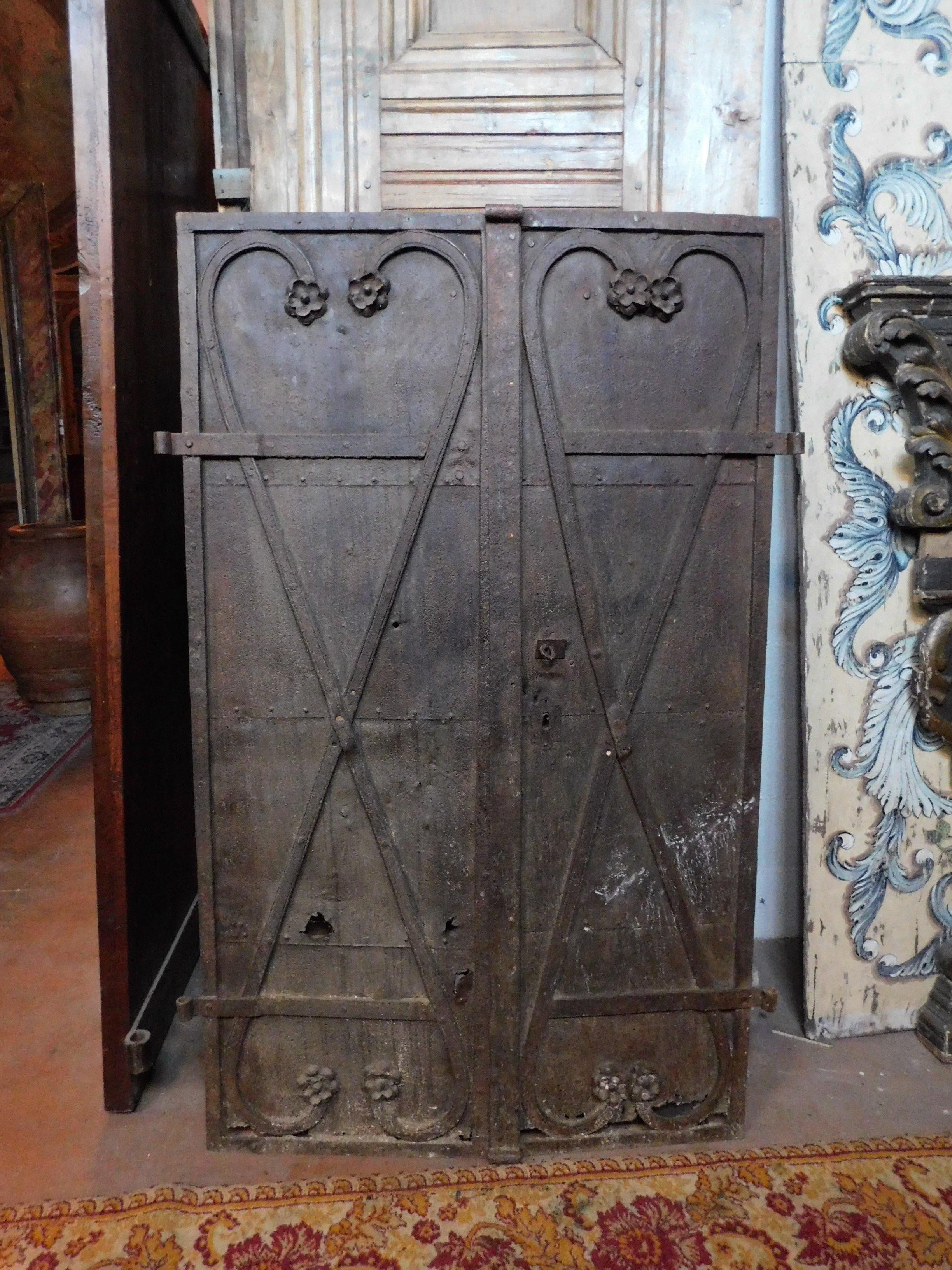 Ancient double door in wrought iron, coming from an ancient castle tower, has x to reinforce the hardness of the door and with carved flowers for decoration, produced entirely by hand towards the end of the 18th century for a castle in