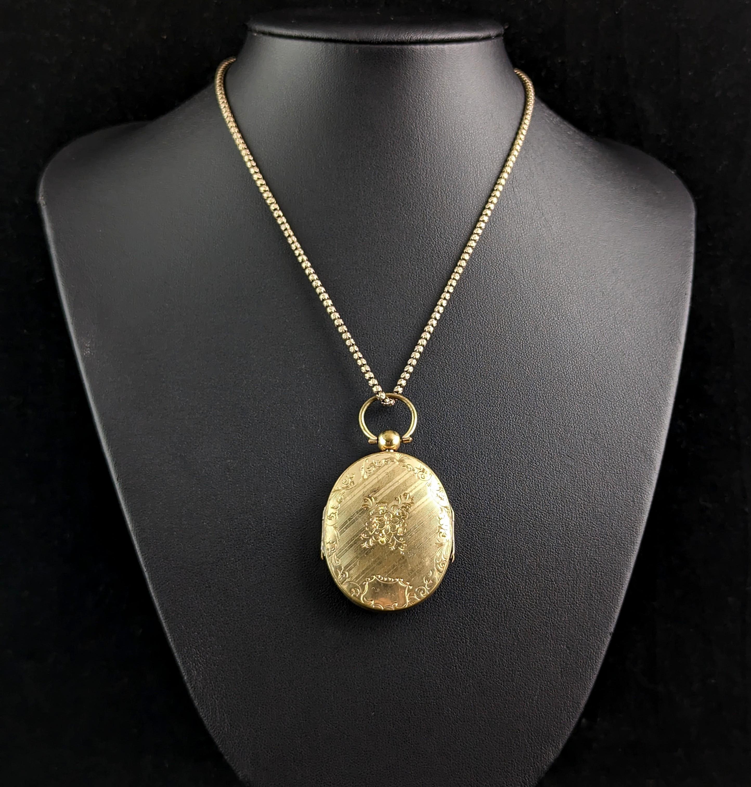 A rare and tragically beautiful antique Victorian era mourning locket necklace.

The locket is a large size, elaborately designed in a rich golden gilt metal, it has a floral design engraving to the front and back and is a double sided locket