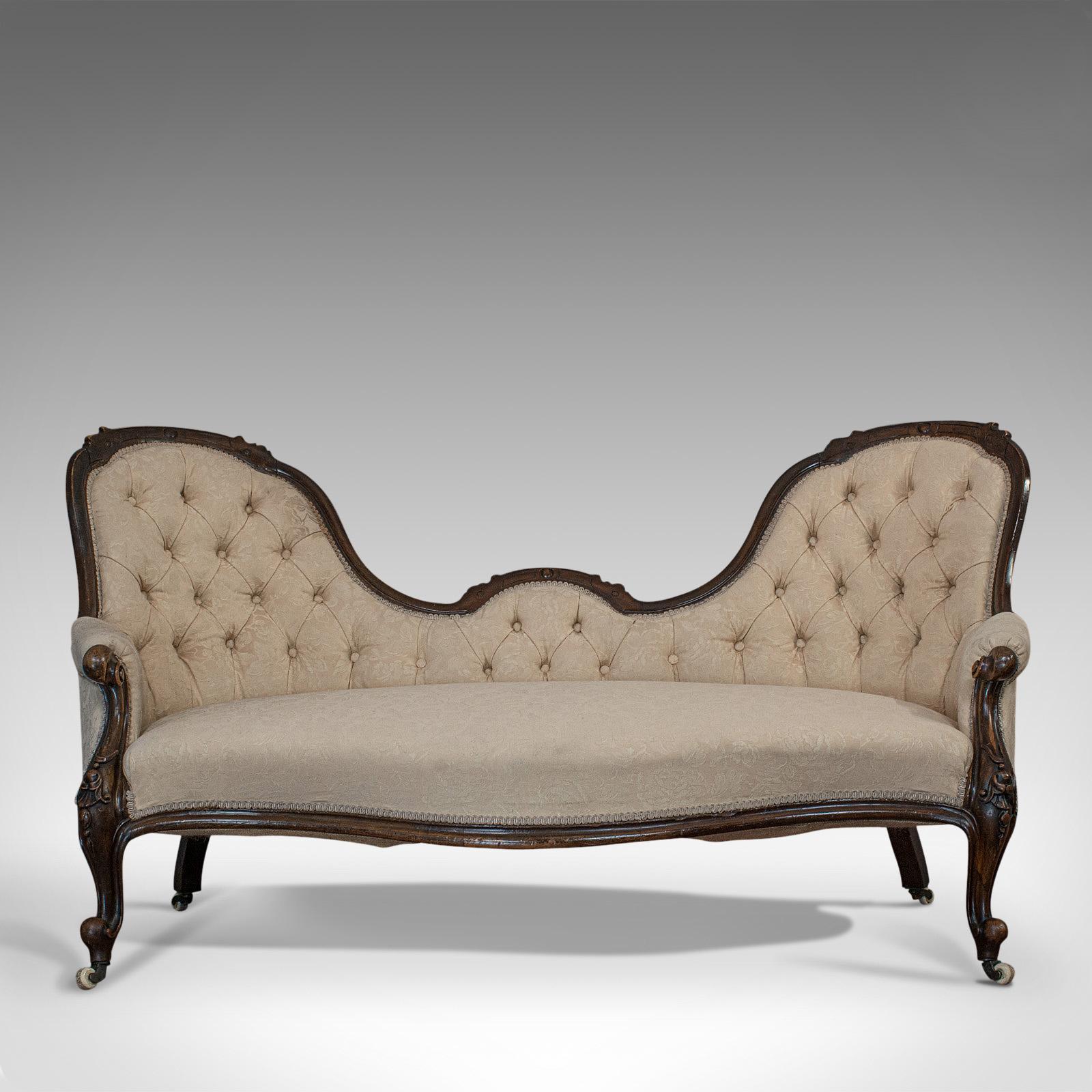 This is an antique double spoonback sofa. An English, walnut camel back settee dating to the Victorian period in the mid-19th century, circa 1850.

Classic Victorian elegance and exuding quality
Displays a desirable aged patina
Select walnut