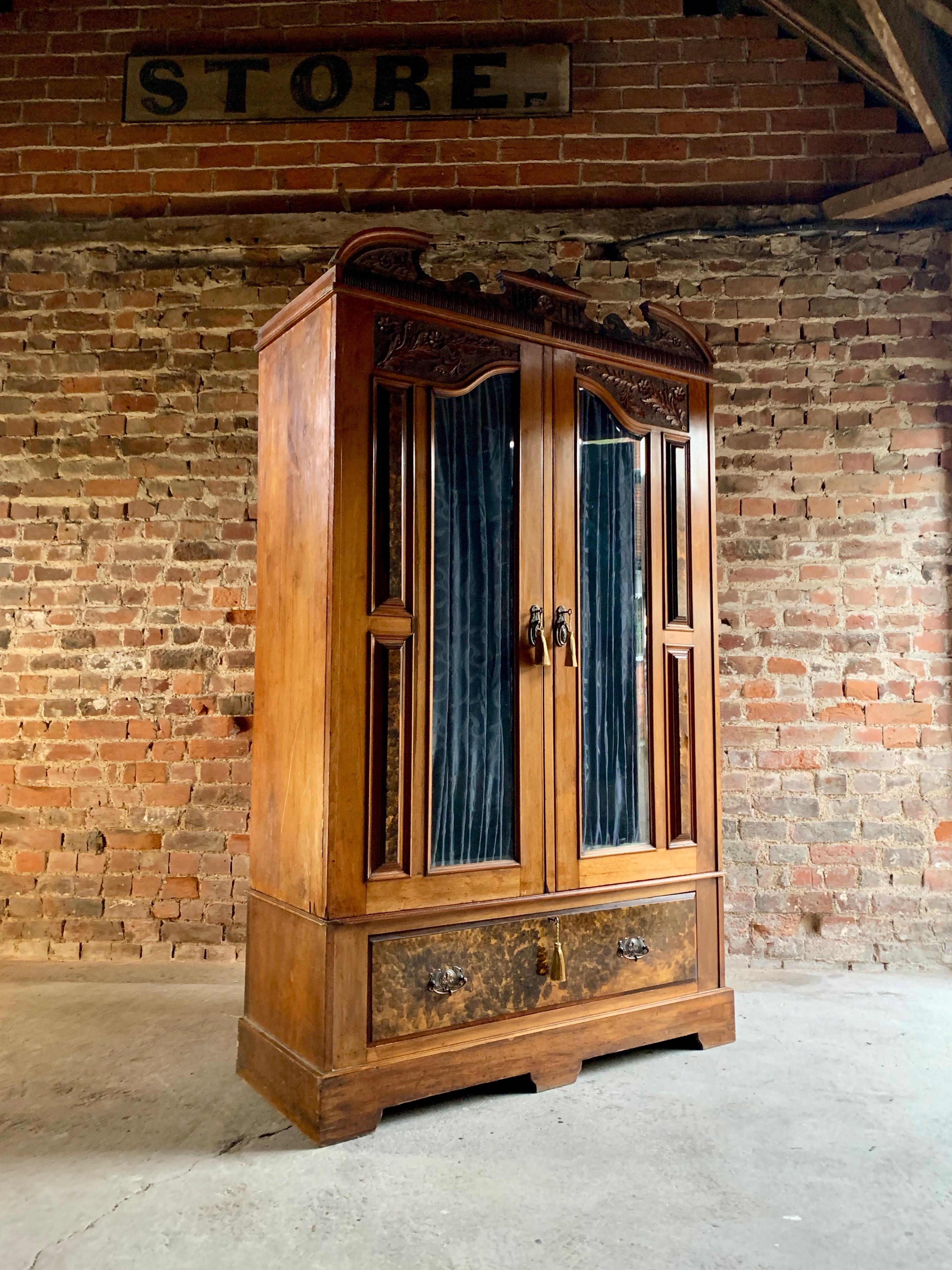 Magnificent antique Edwardian walnut double wardrobe circa 1903, carved and shaped pediment over pair of doors with glazed panels with inset silk curtains, inside divided in two for 'his n hers' areas with hanging rails and hooks, over large pull