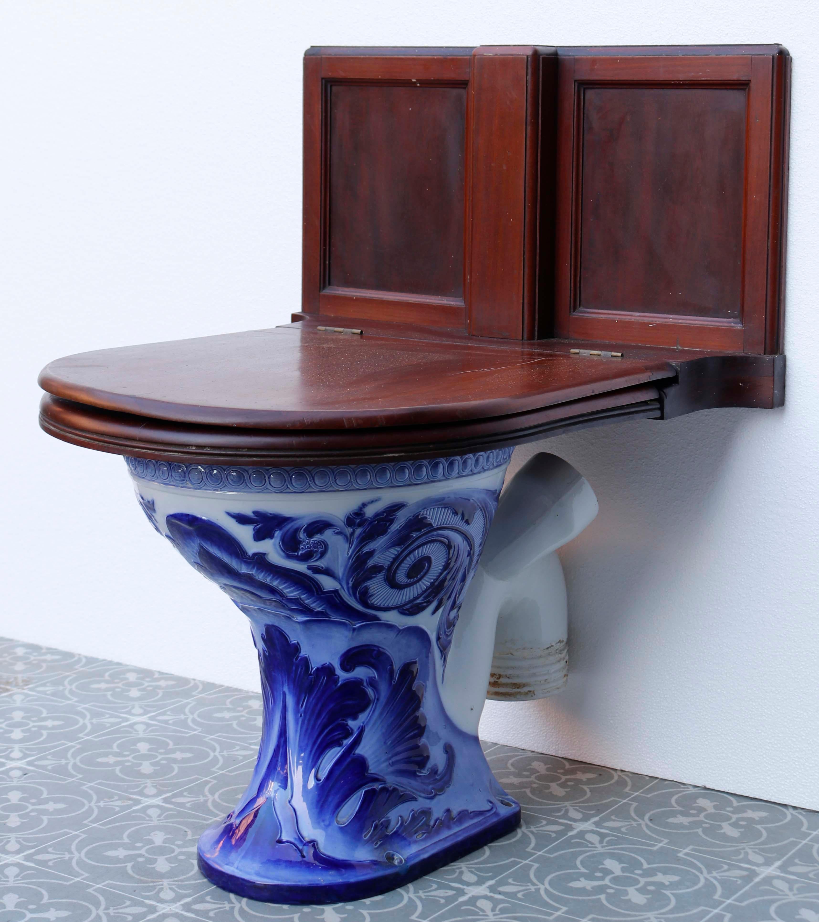 Antique Doulton and Co Glazed toilet. Une toilette en porcelaine émaillée bleue avec des figures originales proéminentes. Le siège en acajou s'harmonise avec les toilettes en porcelaine bleue et blanche qui se trouvent en dessous, donnant vie au