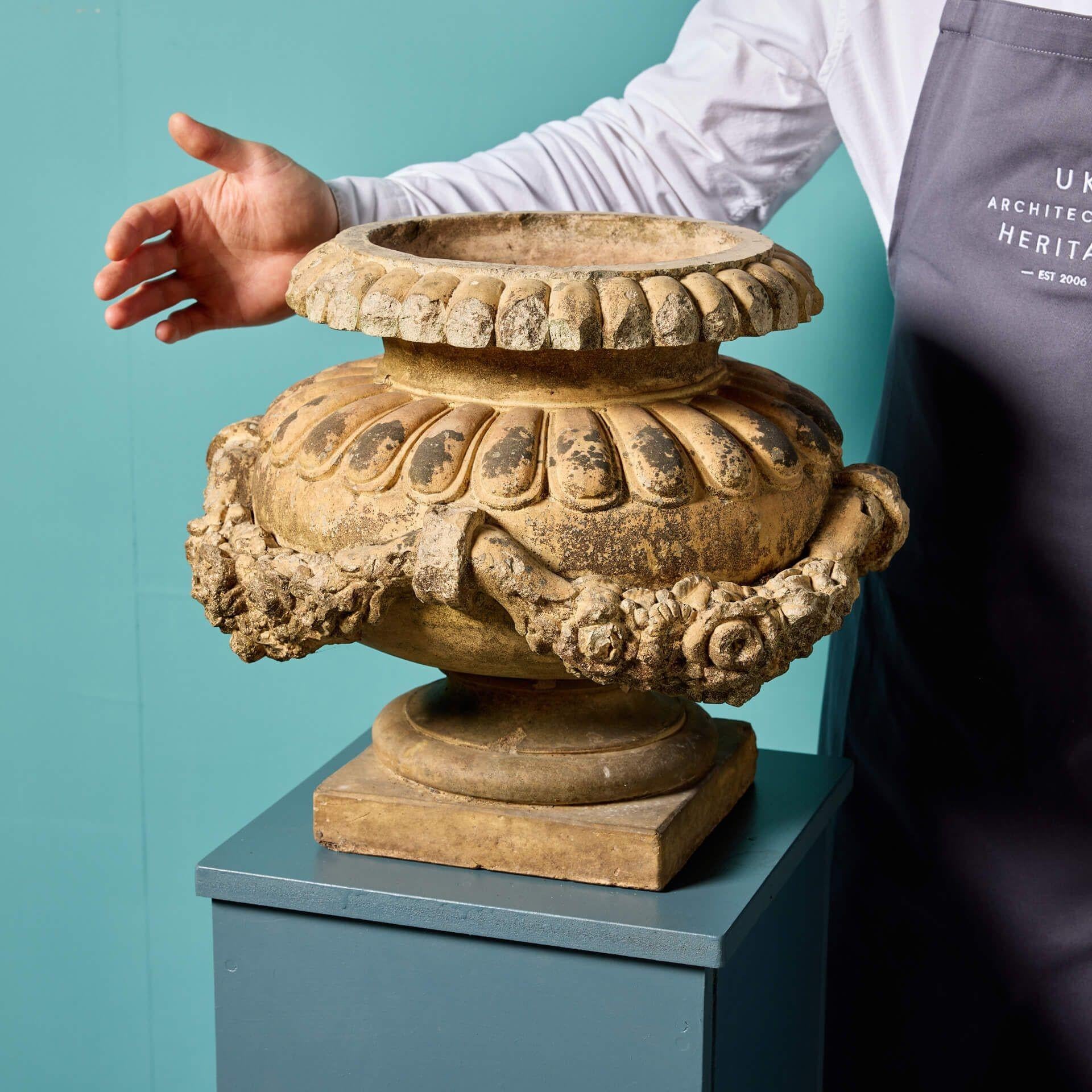 A monumental antique Doulton Lambeth terracotta garden urn. This urn has an interesting and intricate design, decorated with applied floral garlands, with the makers stamp inside the bowl. Dating from the Victorian era, this elaborate urn will stand