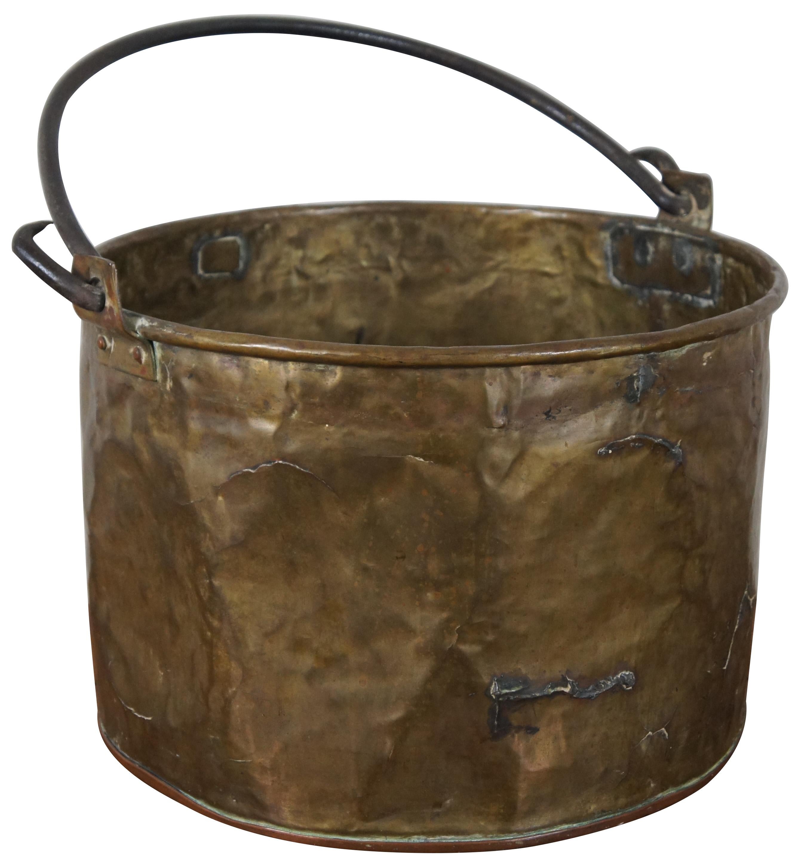 Large antique brass cauldron or stock pot with copper bottom and forged iron handle. Measure: 17”.