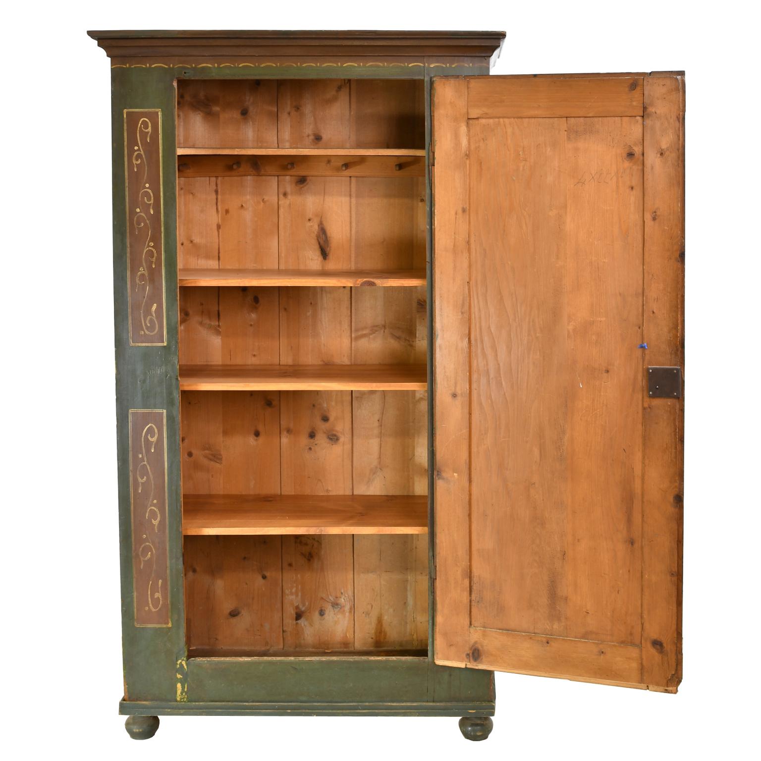 A lovely wedding or dowry armoire with the original painted finish, and dated 1798. The dark green background of the armoire is broken by maroon-colored sides, crown molding and painted panels with foliate design. The single door offers a floral