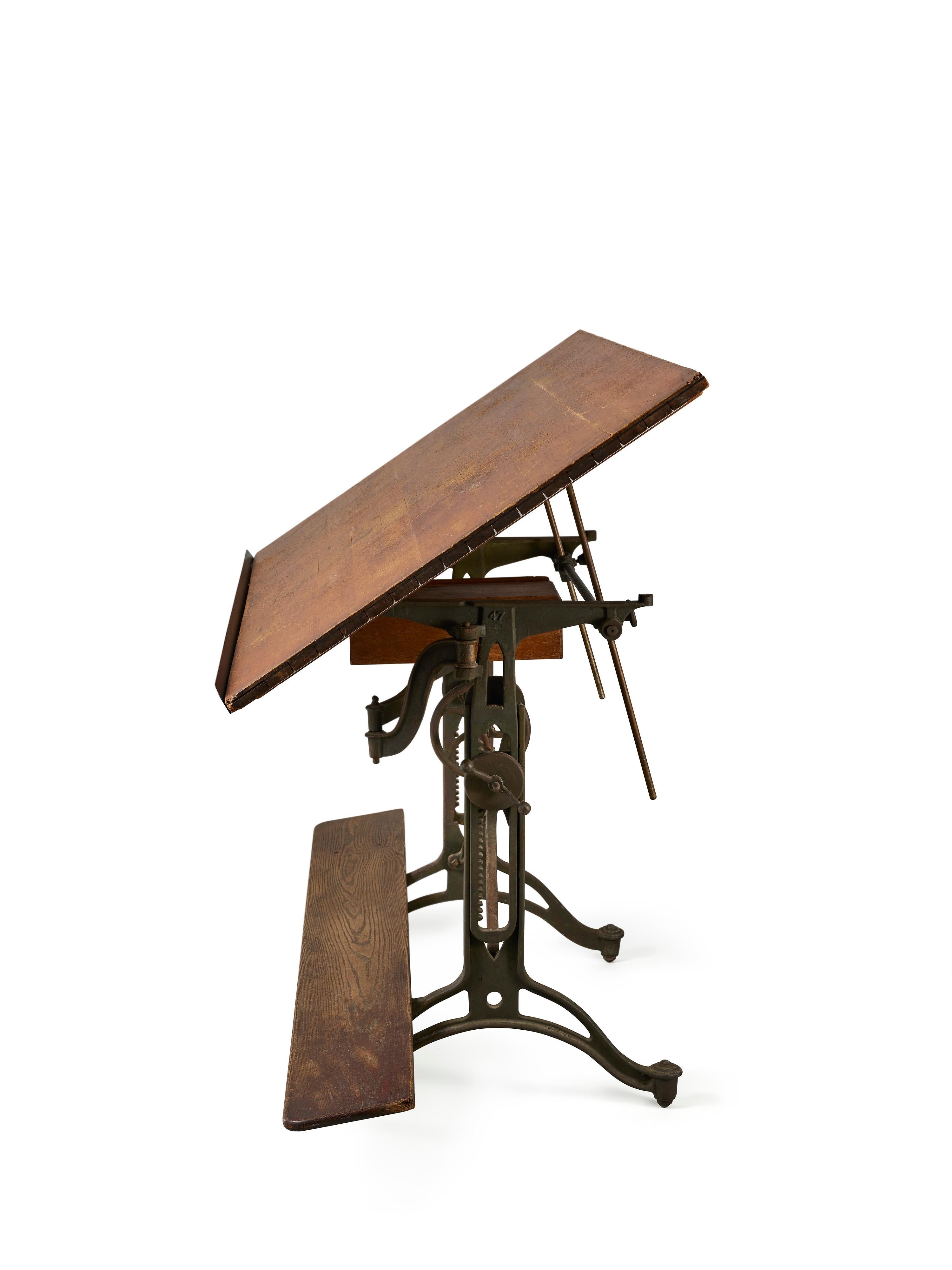This impressive drafting table boasts a signature X- shape iron base, perfect for use as a standing desk or traditional dining table. Its original oak top, refinished with breadboard ends, adds to its charm. The mechanics operate smoothly, allowing