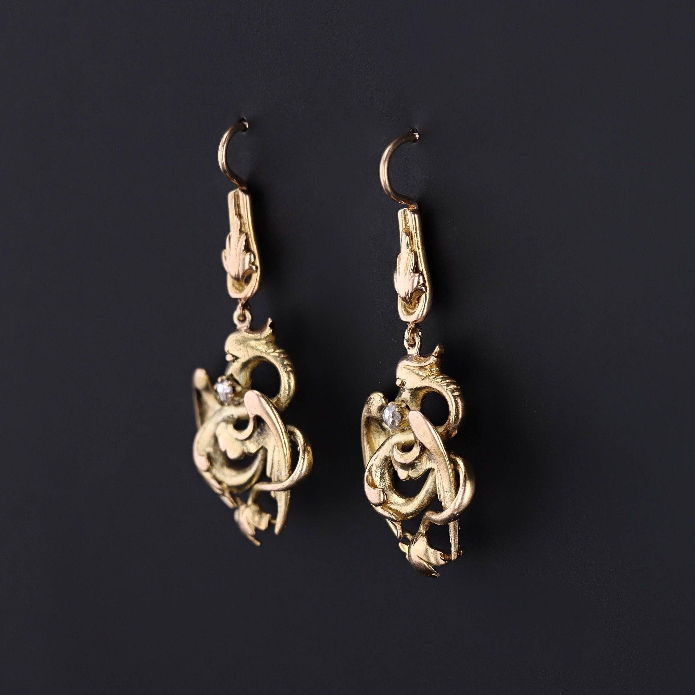 Questi eleganti pendenti sono stati ricavati da spille antiche (circa 1910-1920) e presentano draghi in oro 14k, ognuno dei quali porta un diamante nelle fauci.

Ogni orecchino misura 1,65 pollici dalla parte superiore del filo per orecchio alla