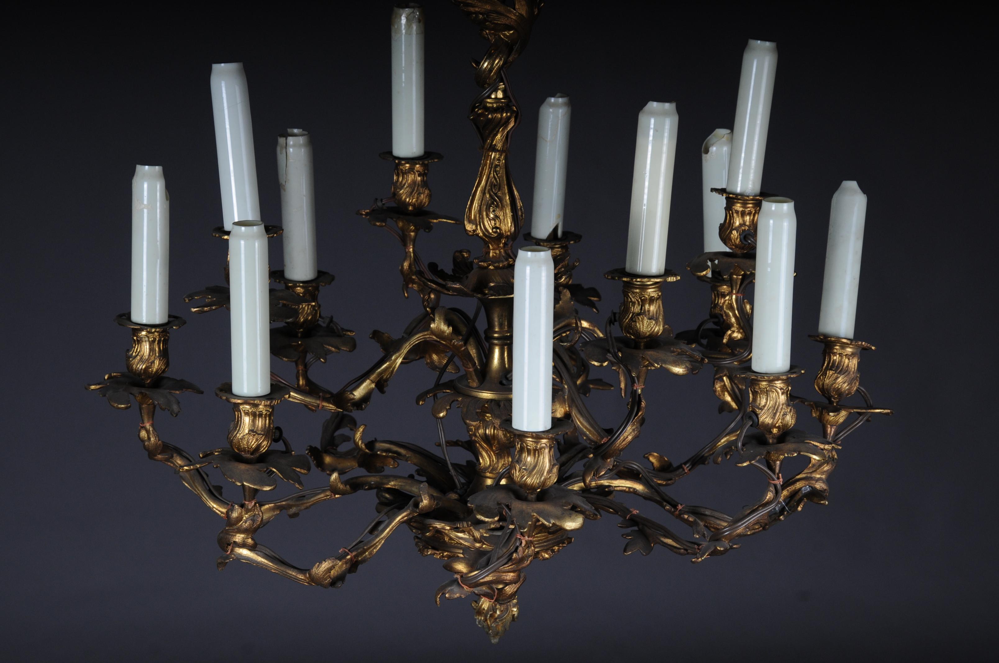 Antique Dresden Baroque chandelier, circa 1880.

Gilded bronze casting. Multiple curly arms. High, decorated shaft with 12 externally placed flames. Fontanienbekrönung. Candle-shaped pods.

(F - 88).