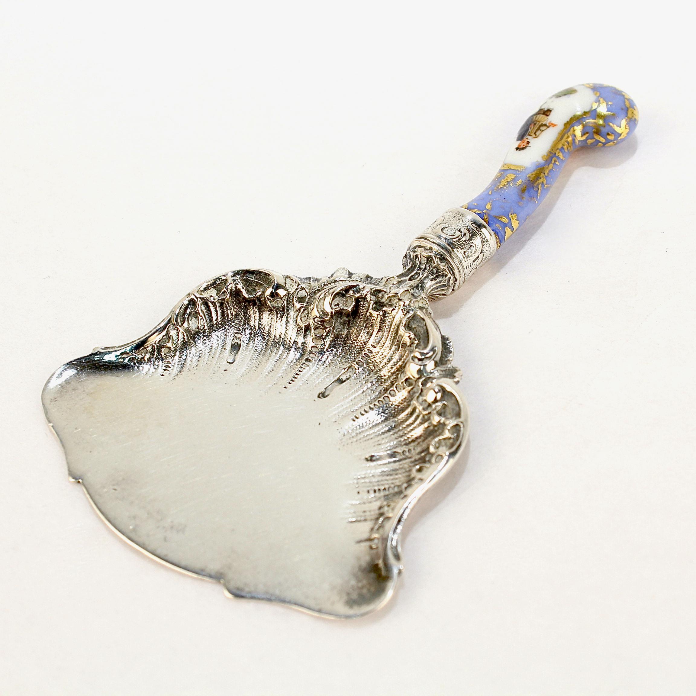 A fine antique Dresden nut scoop or petit four server.

Comprised of an ornate 800 silver scoop and mounted with a hand-painted Dresden porcelain handle. 

Marked for Richard Garten of Dresden, Germany, who was active in the 2nd half of the 19th