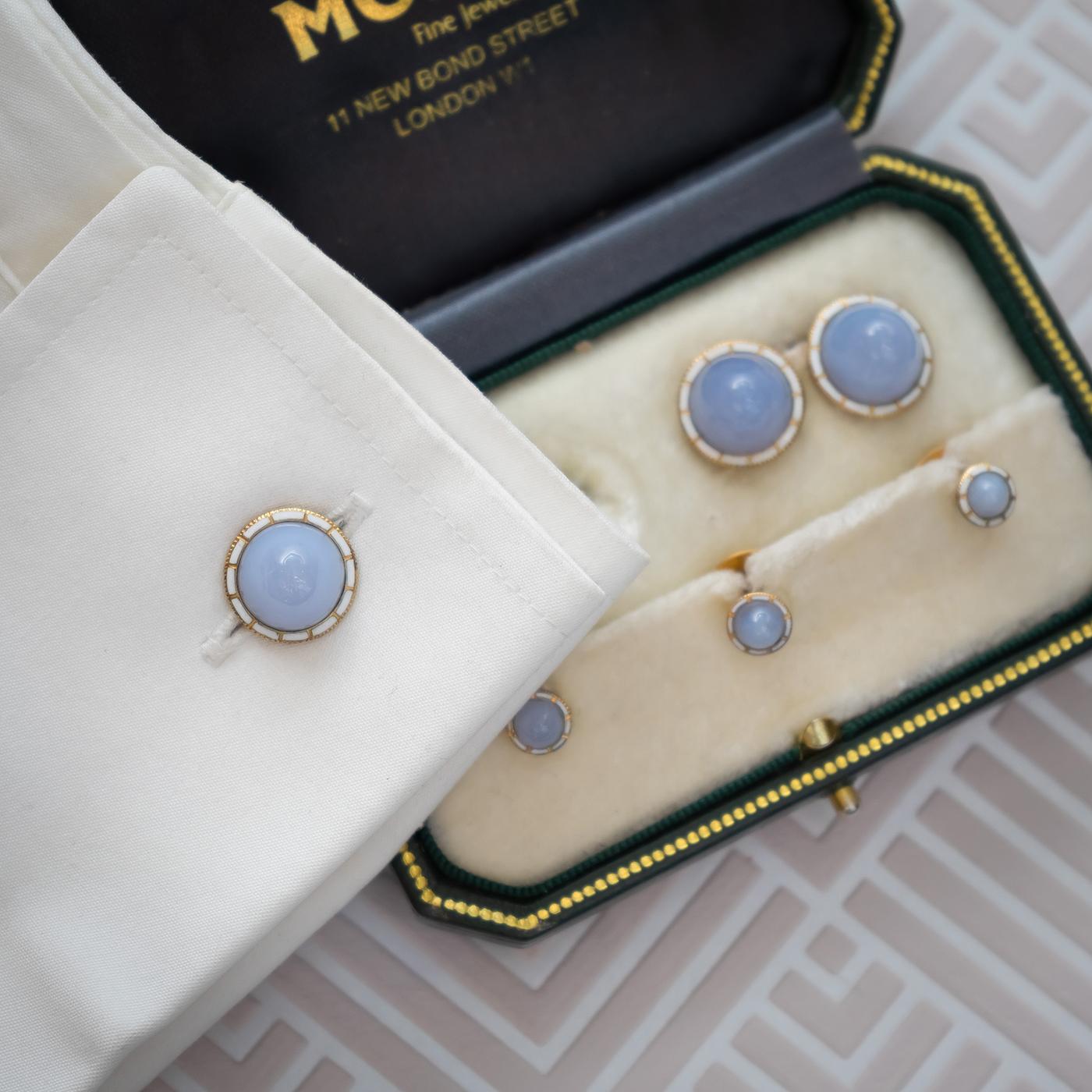 An English, antique, gentleman's dress set, with cabochon-cut blue lace agate and white enamel surrounds, on 15ct gold, comprising of a pair of cufflinks and three studs. Circa 1900.