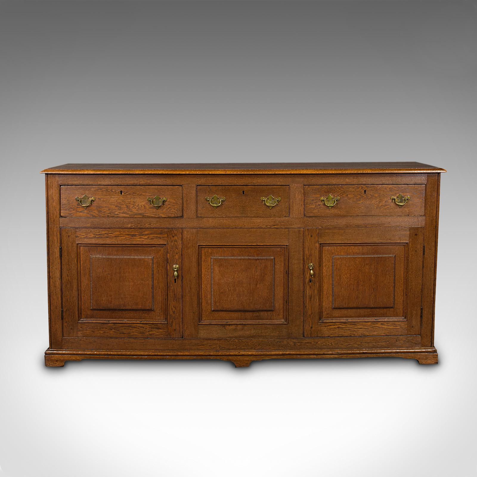 This is an antique dresser base. An English, oak side cabinet with Georgian revival taste, dating to the late Victorian period, circa 1880.

Beautifully figured oak and superb craftsmanship
Displaying a desirable aged patina and in good