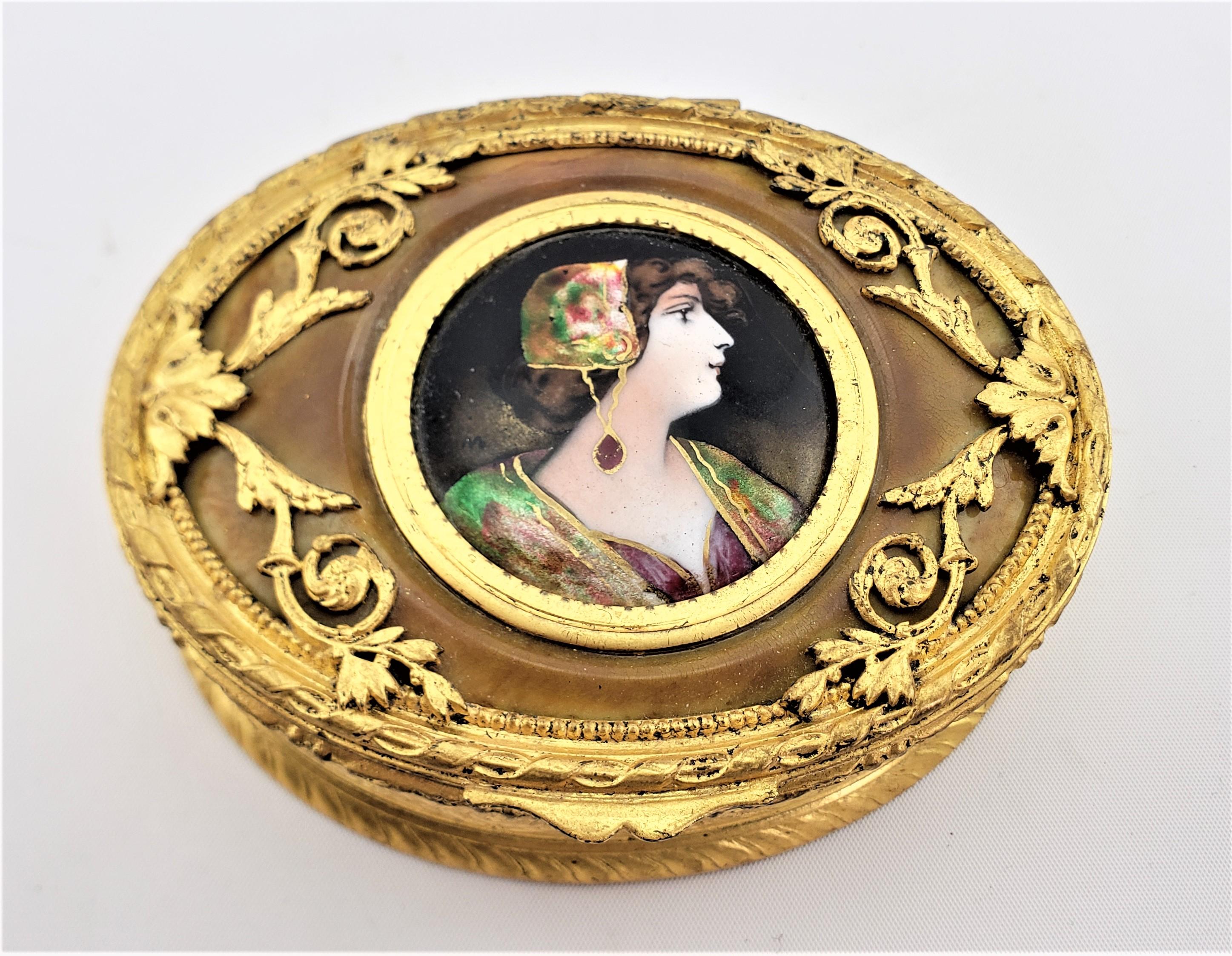 This antique dresser or jewelry box is unsigned, but presumed to have been made in France in approximately 1890 in the period Art Nouveau style. The oval shaped box has a very well executed hand-painted enamel portrait, likely on copper, in a