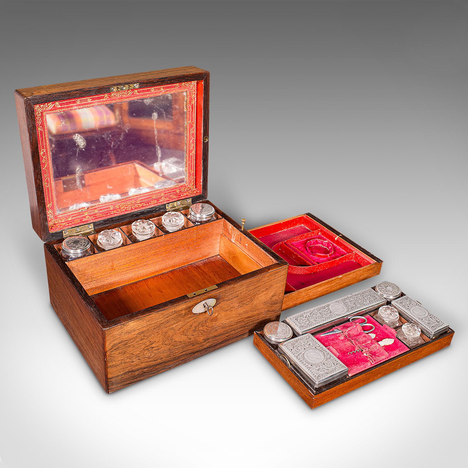 
Dies ist eine antike Schminktischbox. Ein englischer verspiegelter Boudoir-Eitelkeitskasten aus Palisanderholz aus der frühen viktorianischen Zeit um 1850.

Hervorragende Verkleidungen mit einer charmanten Reihe von Einbaugläsern
Zeigt eine