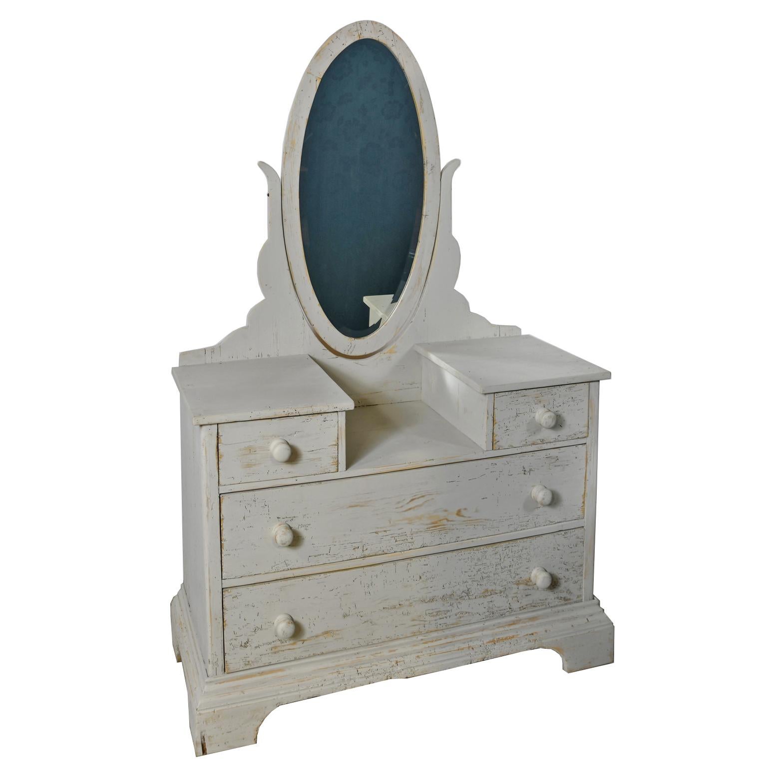 A late 19th century pine chest of drawers or dressing table with newly-painted Gustavian grey/white or driftwood color paint. Offers an oval dressing mirror that pivots and rests over a table surface that is flanked on each side by a pedestal