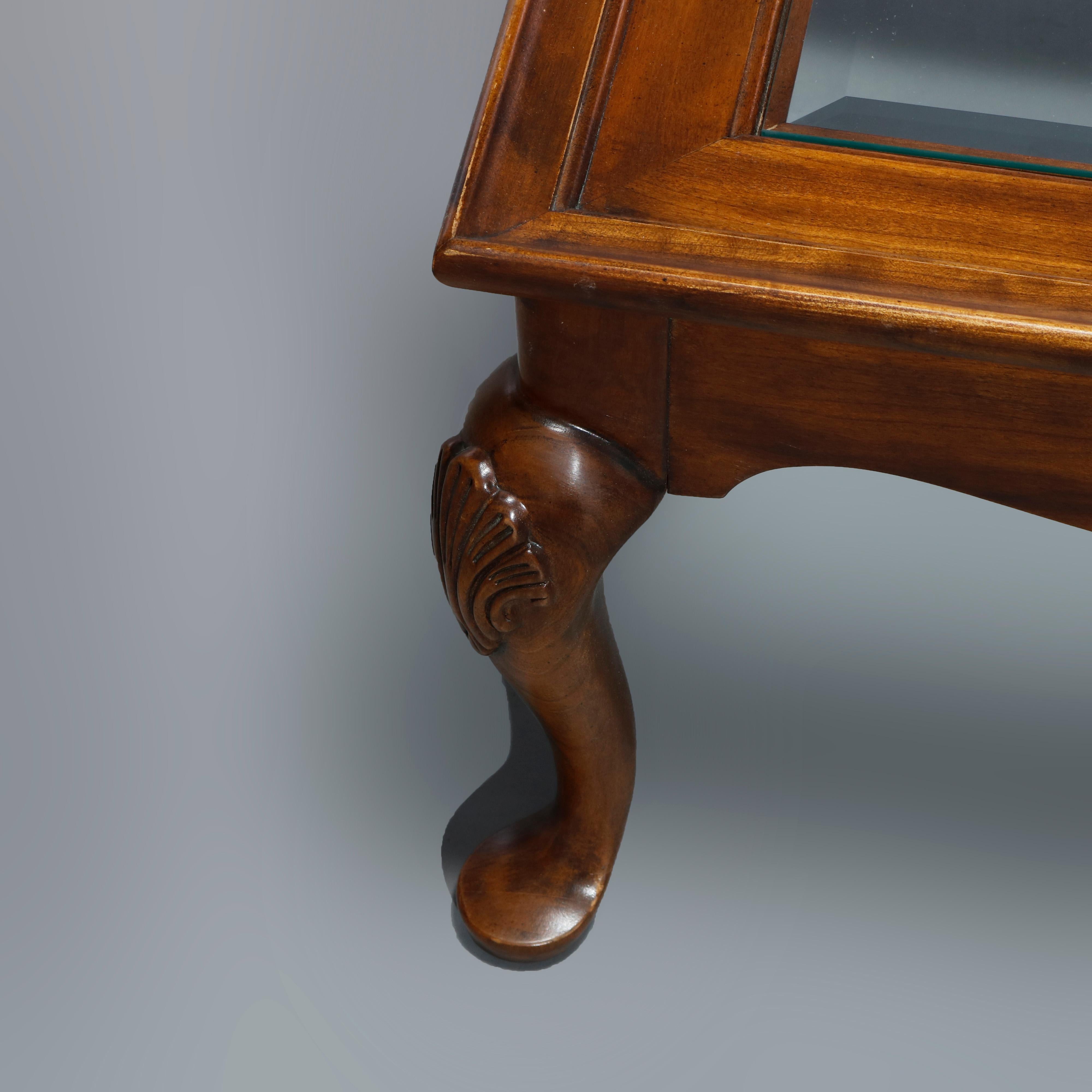 An antique Queen Anne style coffee table by Drexel offers cherry construction with top having four beveled glass panels over shaped skirt and raised on cabriole legs with foliate carved knees and terminating in pad feet, maker stamp as photographed,