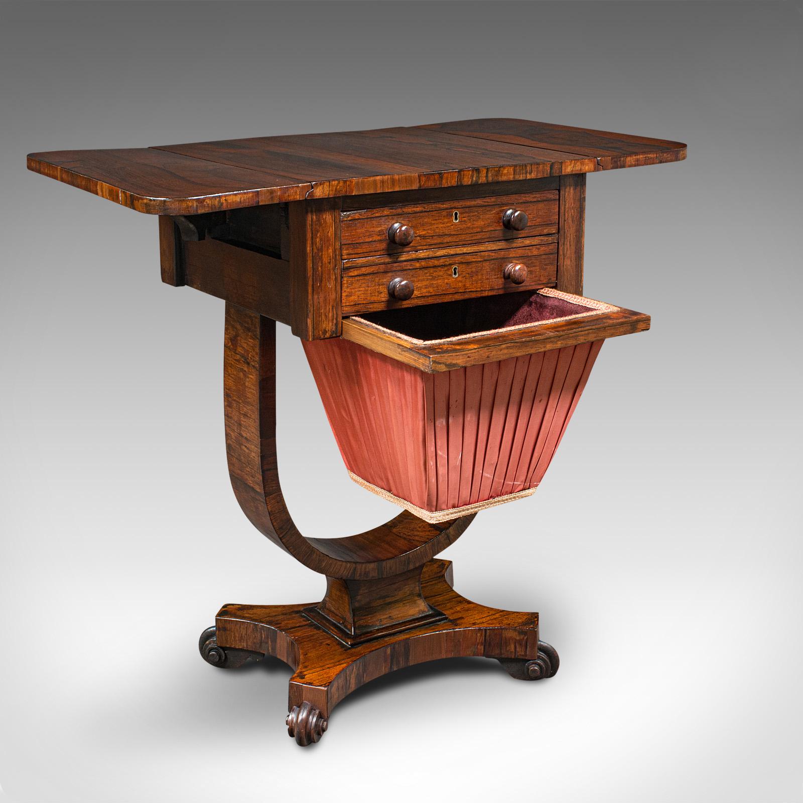 This is an antique drop leaf ladies work table. An English, rosewood sewing or side table with, dating to the William IV period, circa 1835.

Fascinatingly appointed sewing table with wonderful late Georgian craftsmanship
Displaying a desirable aged