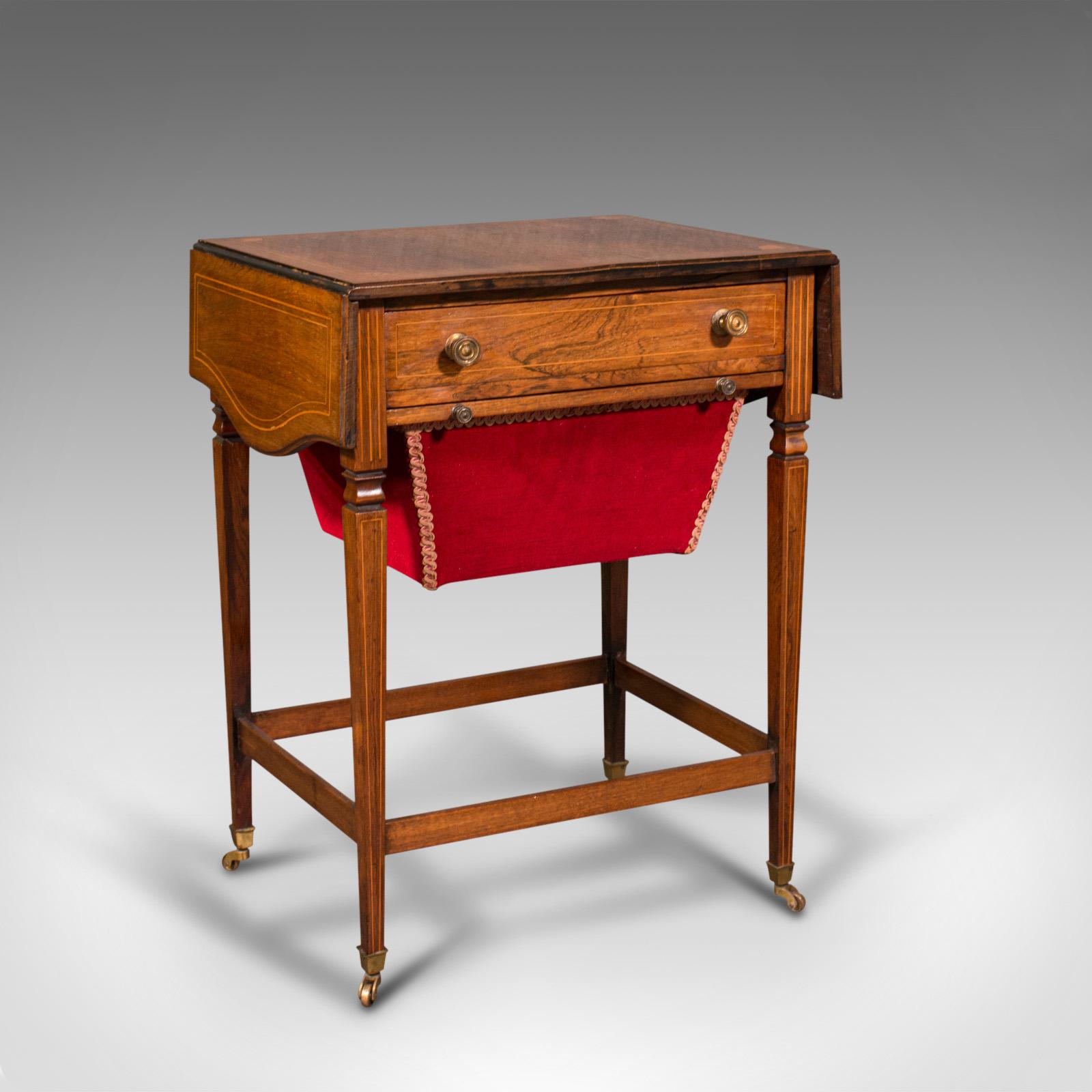 This is an antique drop leaf sewing table. An English, rosewood side or lamp table with boxwood inlay, dating to the Regency period, circa 1820.

Elegant sewing companion with wonderful late Georgian craftsmanship
Displays a desirable aged patina