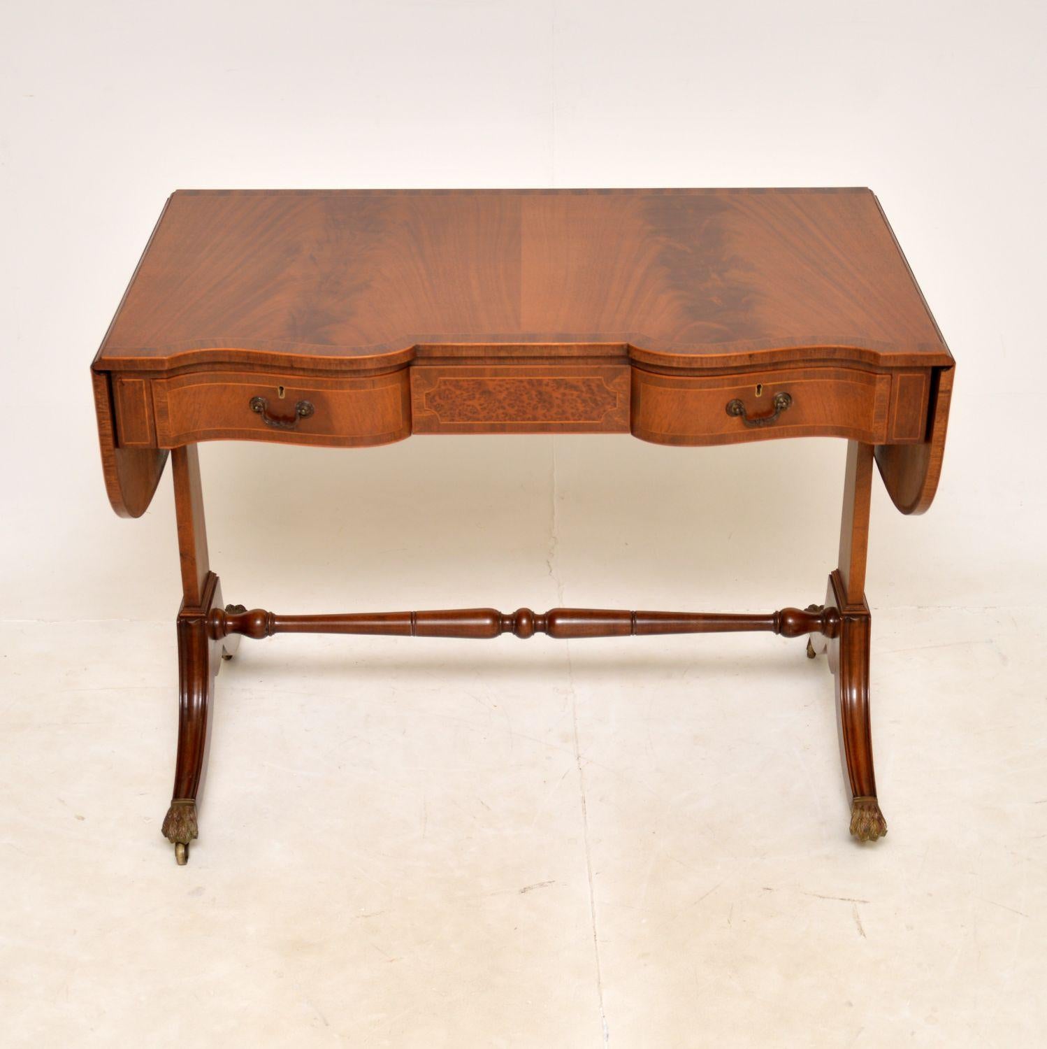 A smart and stylish antique drop leaf sofa table. This was made in England, it dates from around the 1920s.

It is of superb quality and has a gorgeous design. It is predominantly walnut, with cross banded edges and a bur yew central drawer front.
