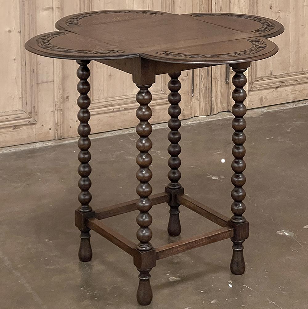 Antique Drop Leaf Spool Leg End Table is a marvel of design and craftsmanship on a wonderfully diminutive scale! Four spooled legs are connected below with stretchers and tipped with teardrop shaped feet, and support the framework of the apron