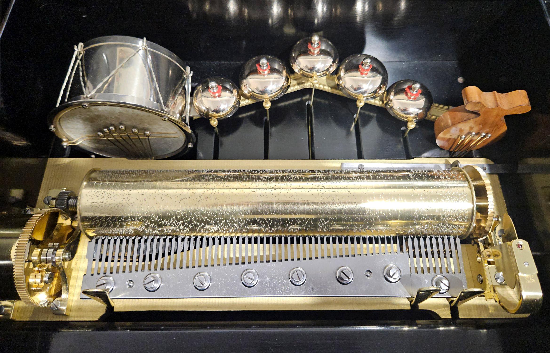 A very nice quality and unusual antique music box with drum, bell and castanet and two-per-turn format made by Ami Rivenc in Geneva, Switzerland c. 1890.

The fully serviced movement features a skin drum with six beaters, five saucer bells mounted