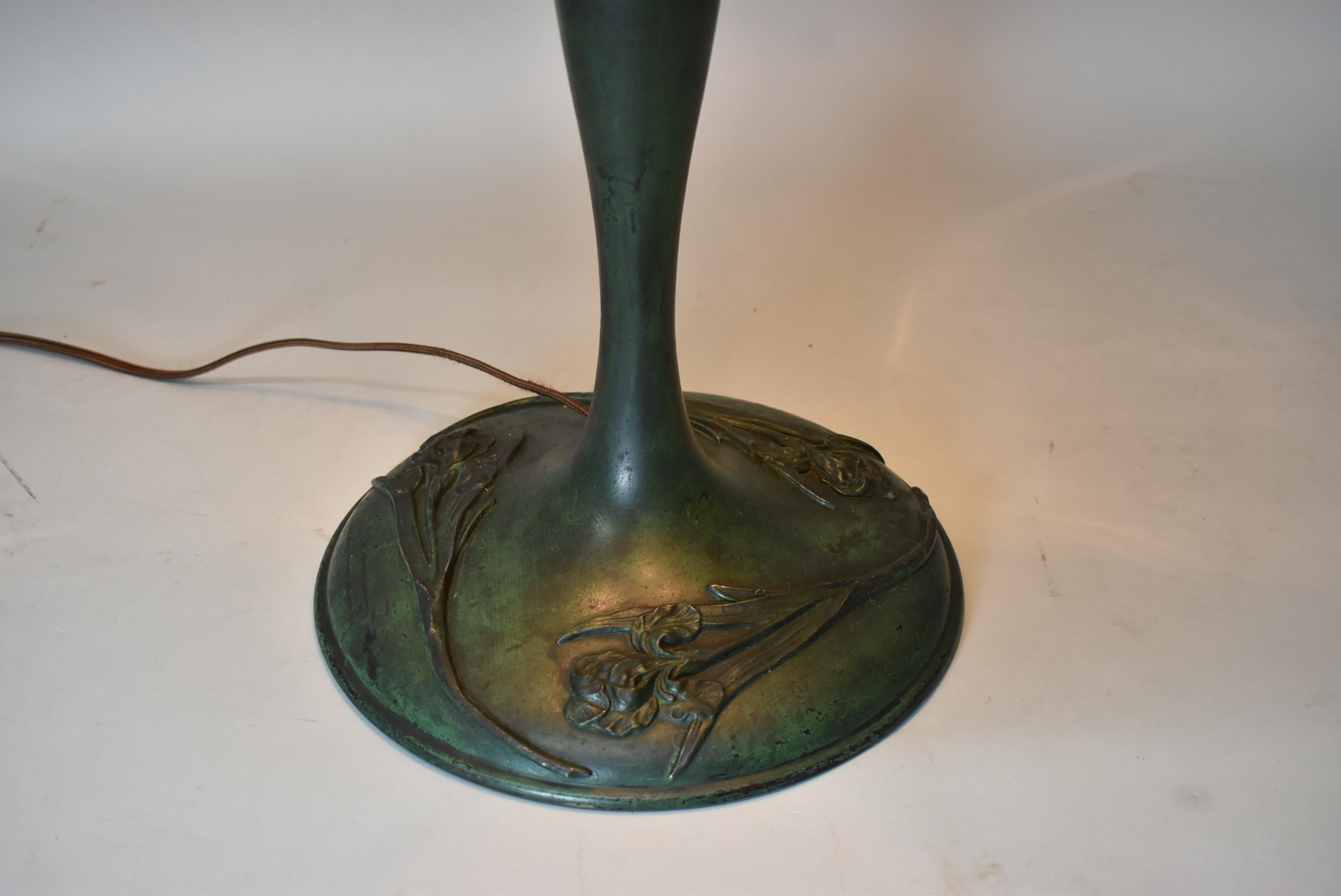 Antique Duffner & Kimberly leaded glass table lamp. Classic design with quality heavy granite back textured glass. Nice base having original green patina with applied iris flowers. Three sockets have ball pulls. Rewired with rayon cord and new plug.