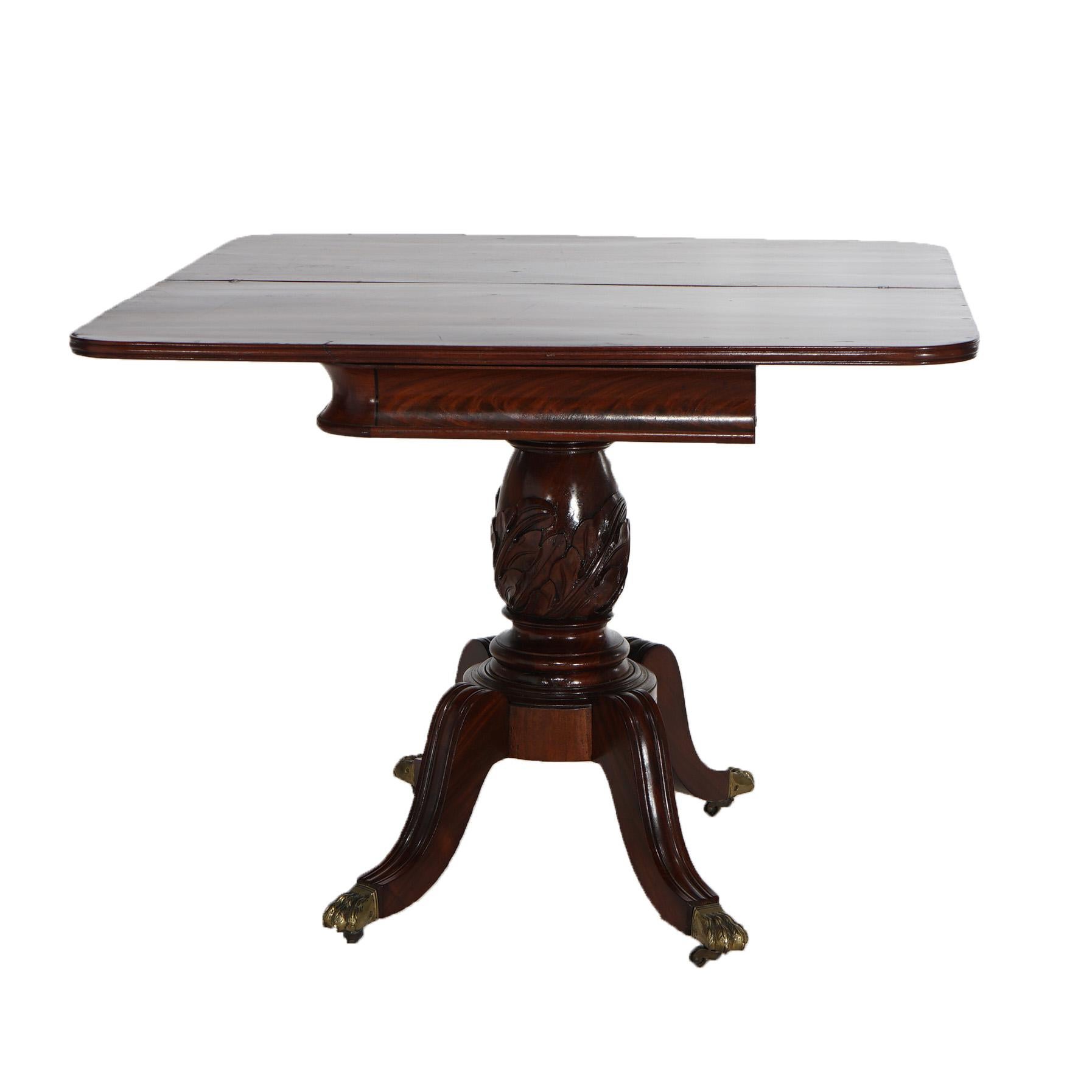 An antique game table in the manner of Duncan Phyfe offers flame mahogany construction with folded top over foliate carved column and raised on convex fluted legs terminating in cast brass caps in paw form, c1830

Measures- 28.75''H x 36''W x 36.5''D
