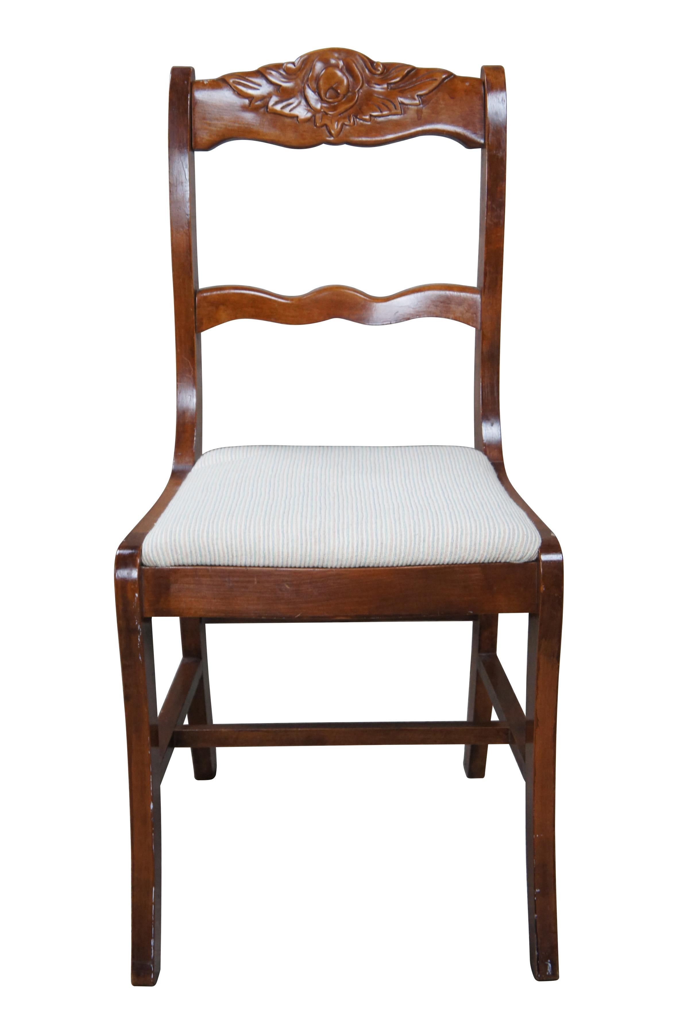 1940s Duncan Phyfe / Regency Style dining side chair.  Made from mahogany with a rose carved crest rail.  Features an upholstered seat with striped pattern.  Front and rear legs are saber shaped and connected by an H stretcher.

Dimensions:
17