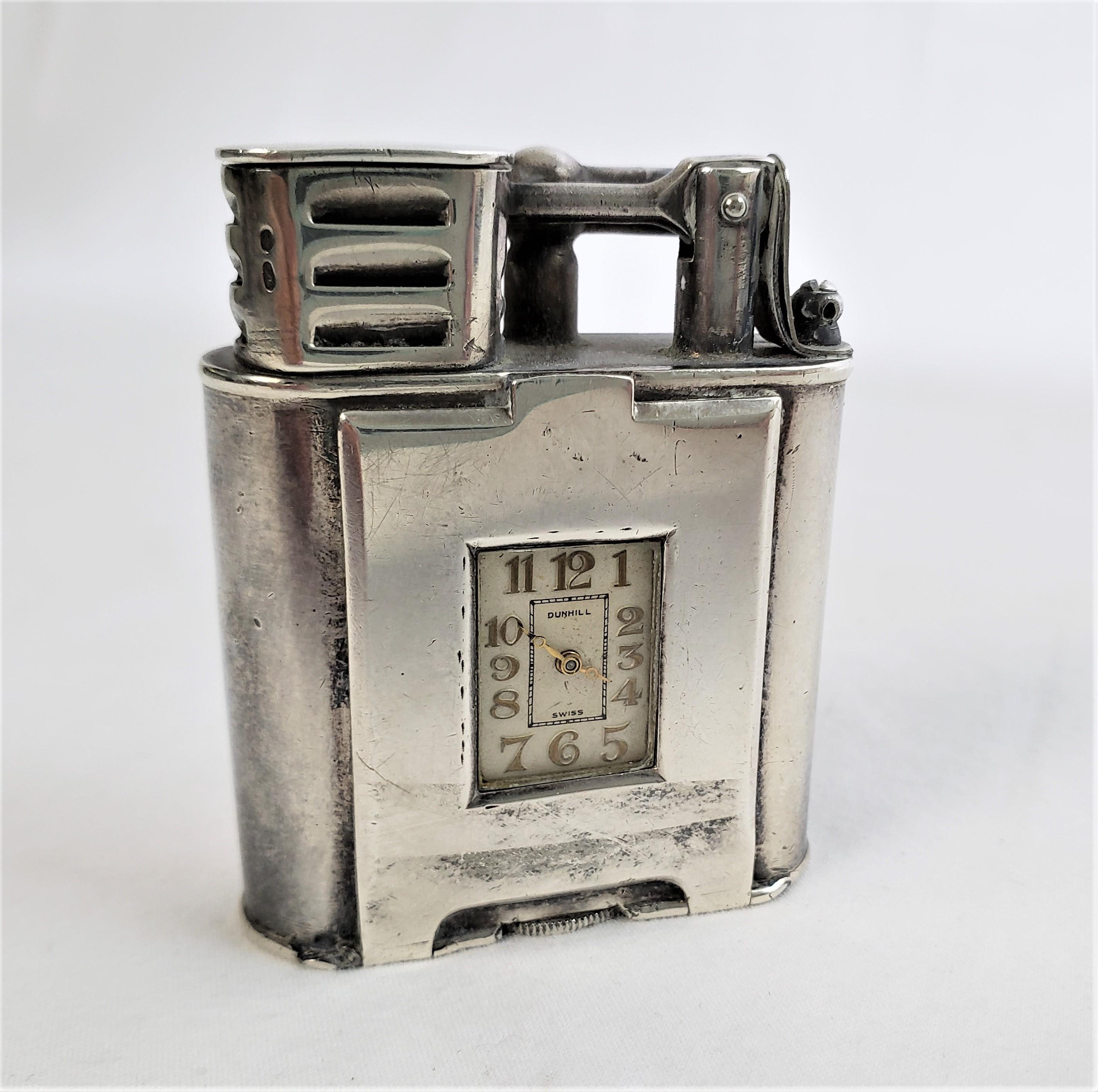 This antique pocket lighter was made by the renowned Dunhill company in approximately 1920 and done in the period Art Deco style. This model is identified as their 'Sports' lighter and the case is composed of sterling silver and features a watch or