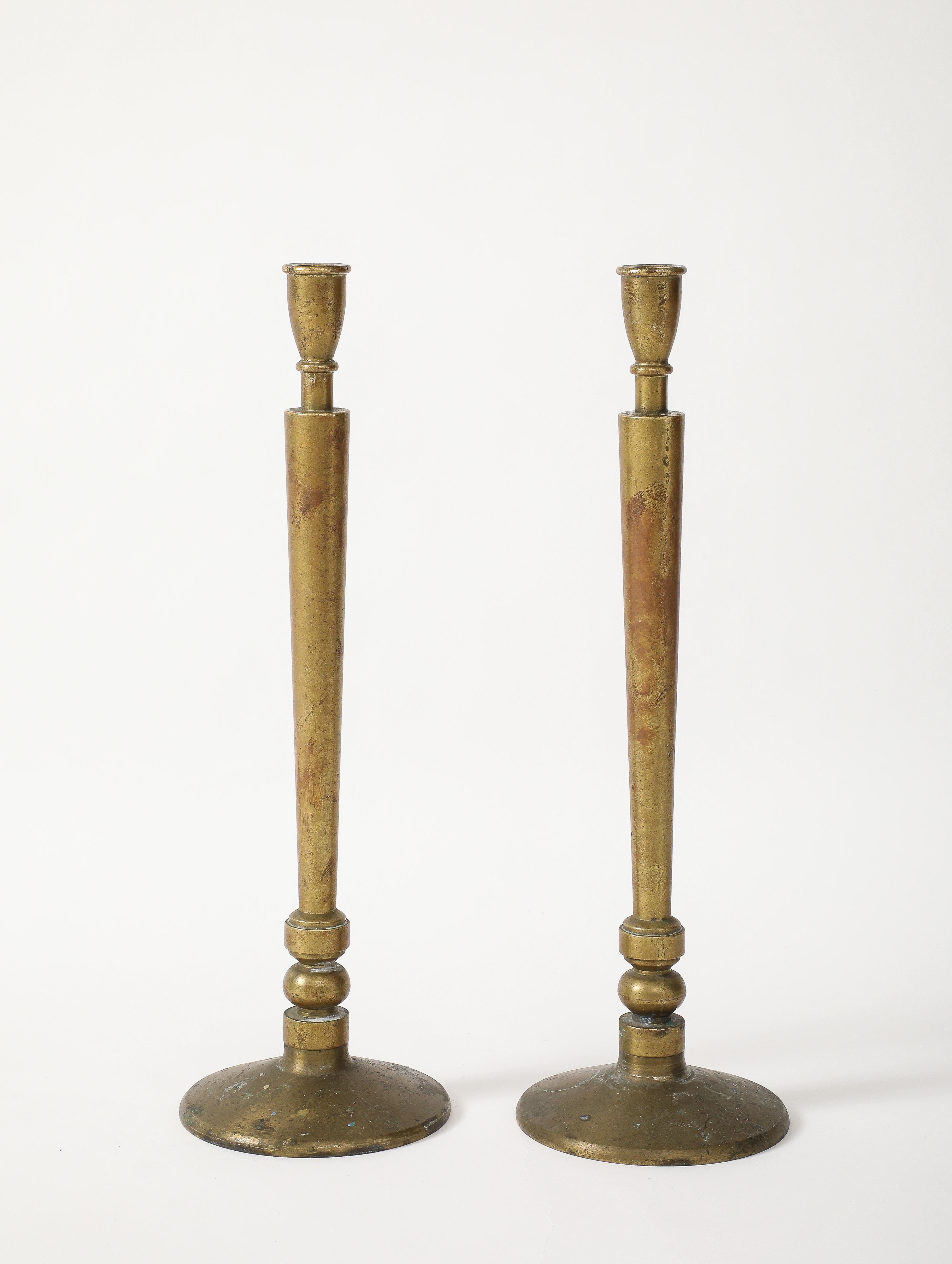 Impressionante coppia di candelabri antichi in ottone massiccio con un design semplicistico ma d'effetto. Patina originale.