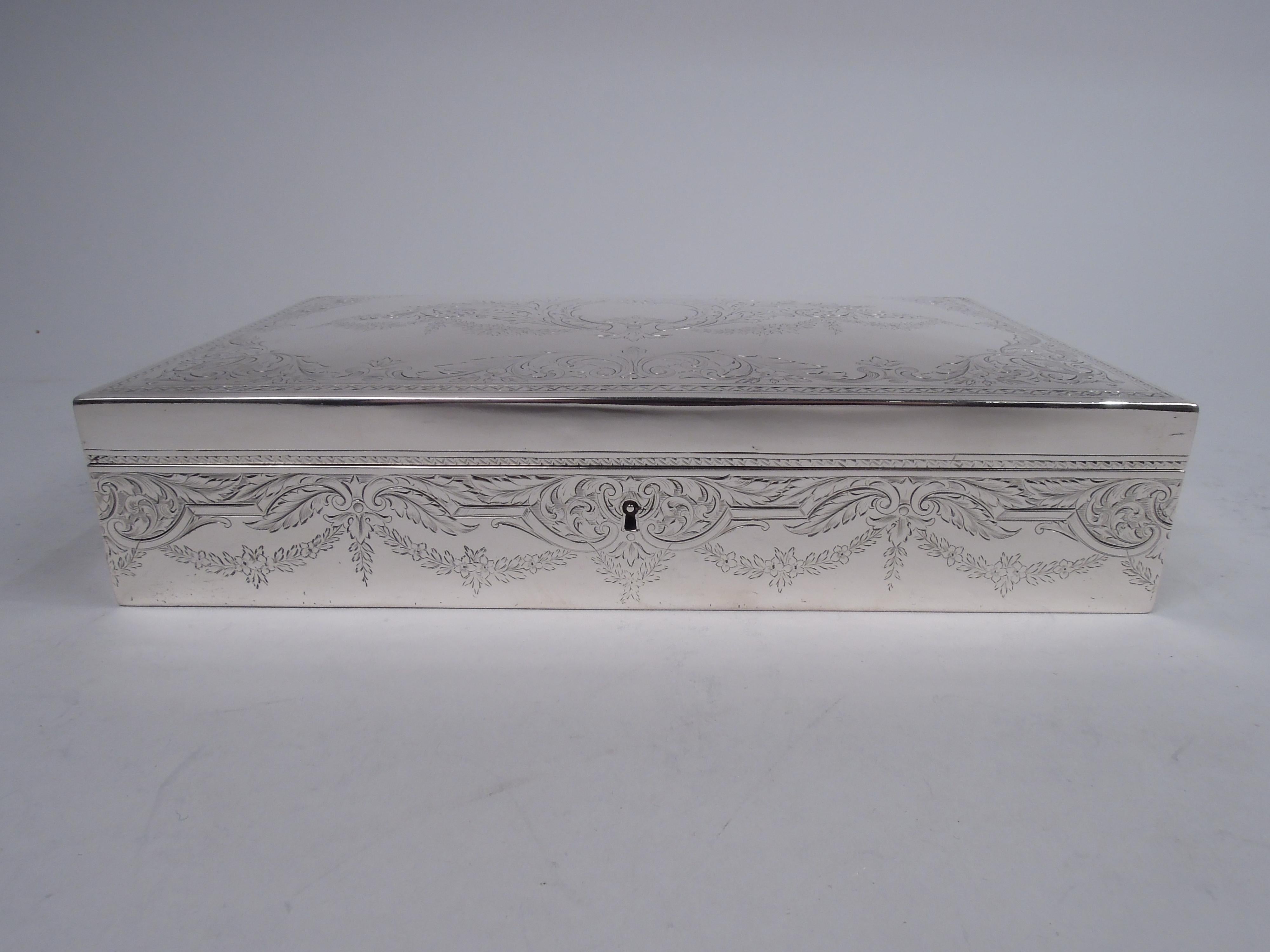 Edwardian Classical sterling silver humidor. Made by William B. Durgin Co. (part of Gorham) in Concord, ca 1910. Rectangular with straight sides; cover hinged with gently curved top. Engraved leafing scrollwork with pendant garlands. On cover top