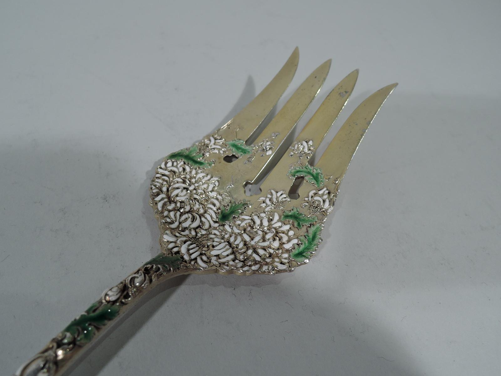 Antique Japonesque gilt sterling silver and enamel serving fork in Chrysanthemum pattern. Made by Durgin in Concord, New Hampshire. Tapering handle with round terminal and wide scalloped shank with 4 tines. Raised double-sided ornament comprising