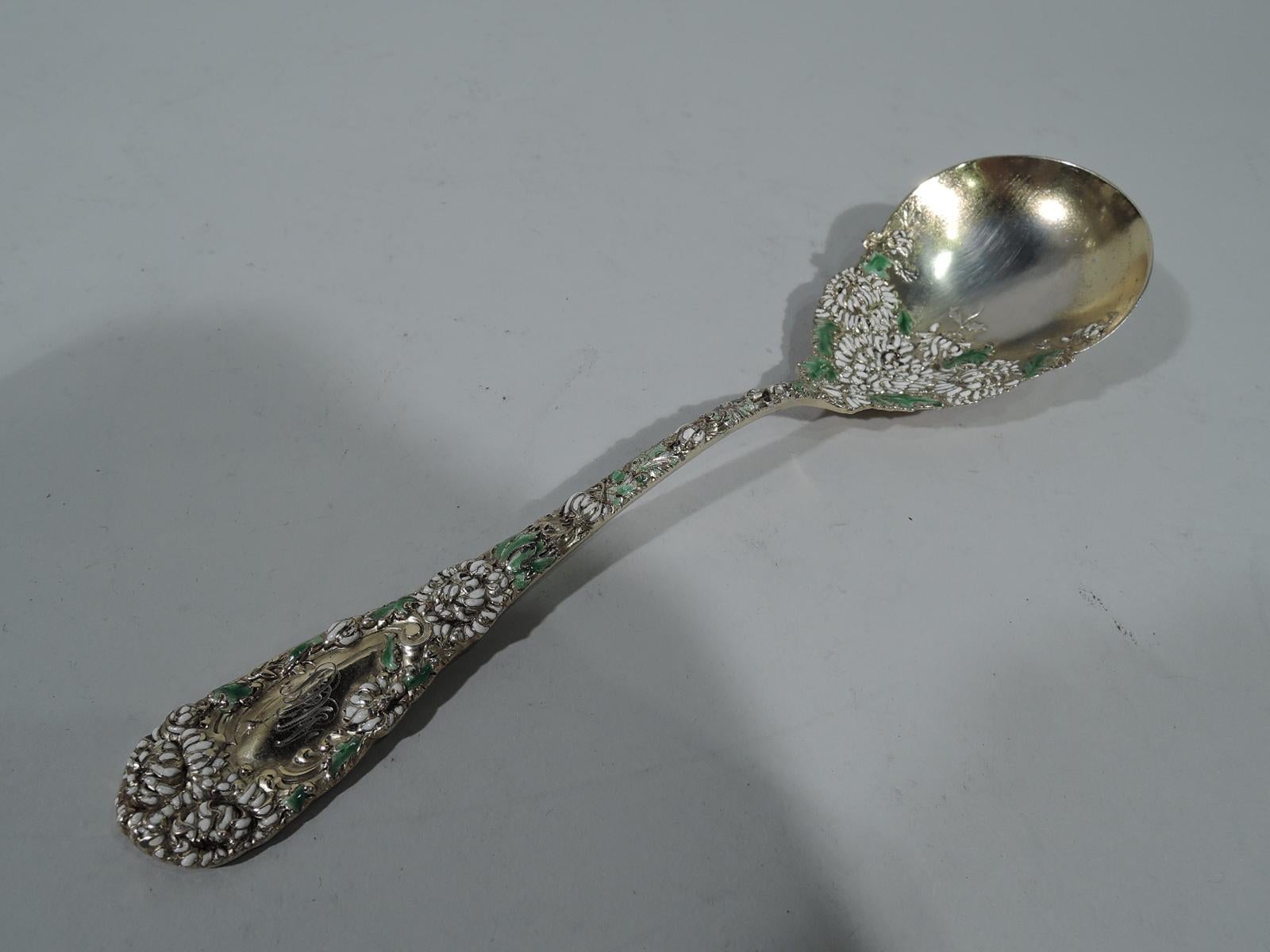 Antique Japonesque gilt sterling silver and enamel berry spoon in Chrysanthemum pattern. Made by Durgin in Concord, New Hampshire. Tapering handle with round terminal and oval scalloped bowl. Raised double-sided ornament comprising dense flower