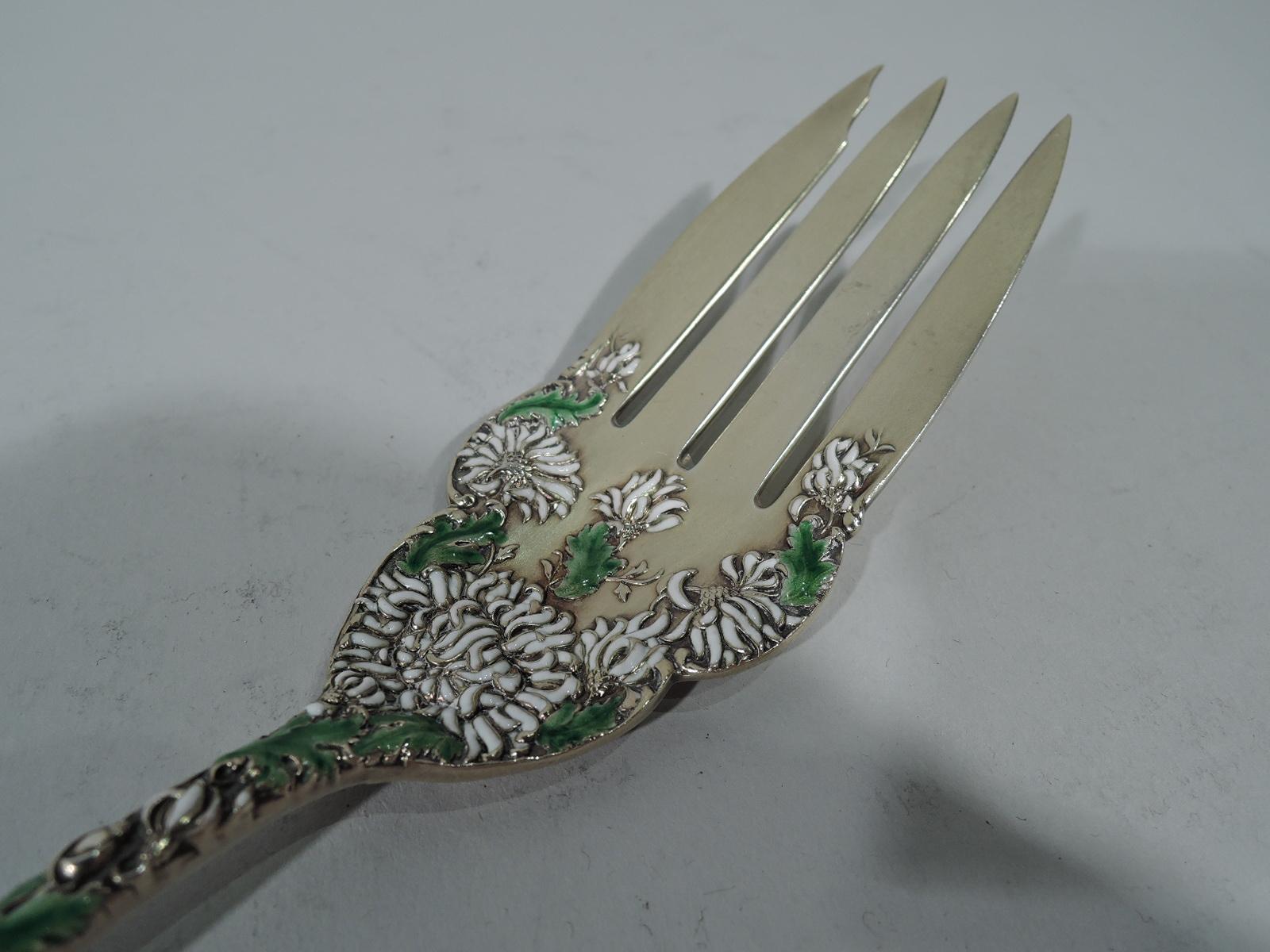 Antique Japonesque gilt sterling silver and enamel serving fork in Chrysanthemum pattern. Made by Durgin in Concord, New Hampshire. Tapering handle with round terminal and narrow scalloped shank with 4 tines. Raised double-sided ornament comprising
