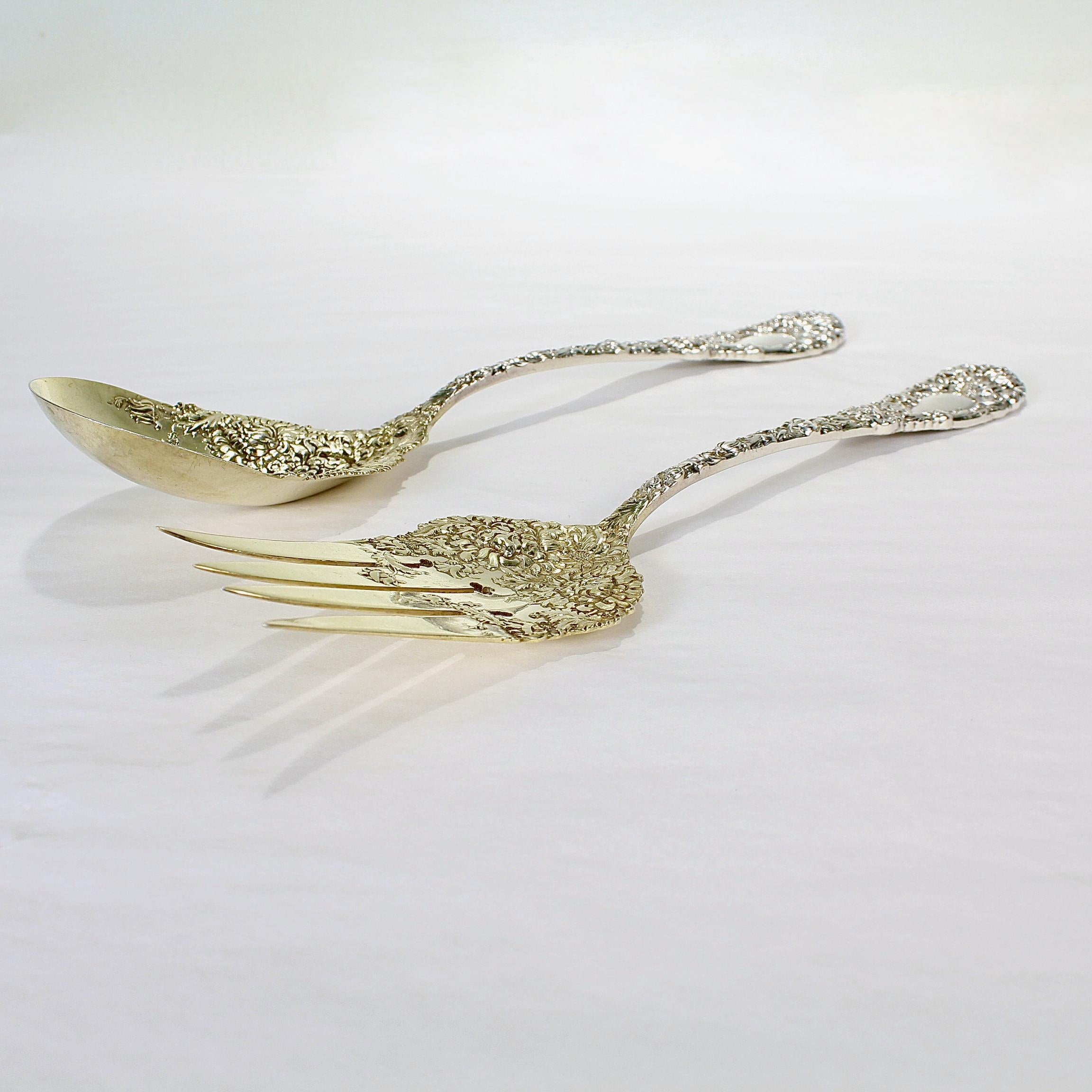 A fine pair of sterling silver salad servers.

By Durgin (and also bearing marks for Black, Starr & Frost).

In sterling silver. 

With a gold wash to both the spoon bowl and fork tines.

Simply a great pair of Chrysanthemum salad servers! 