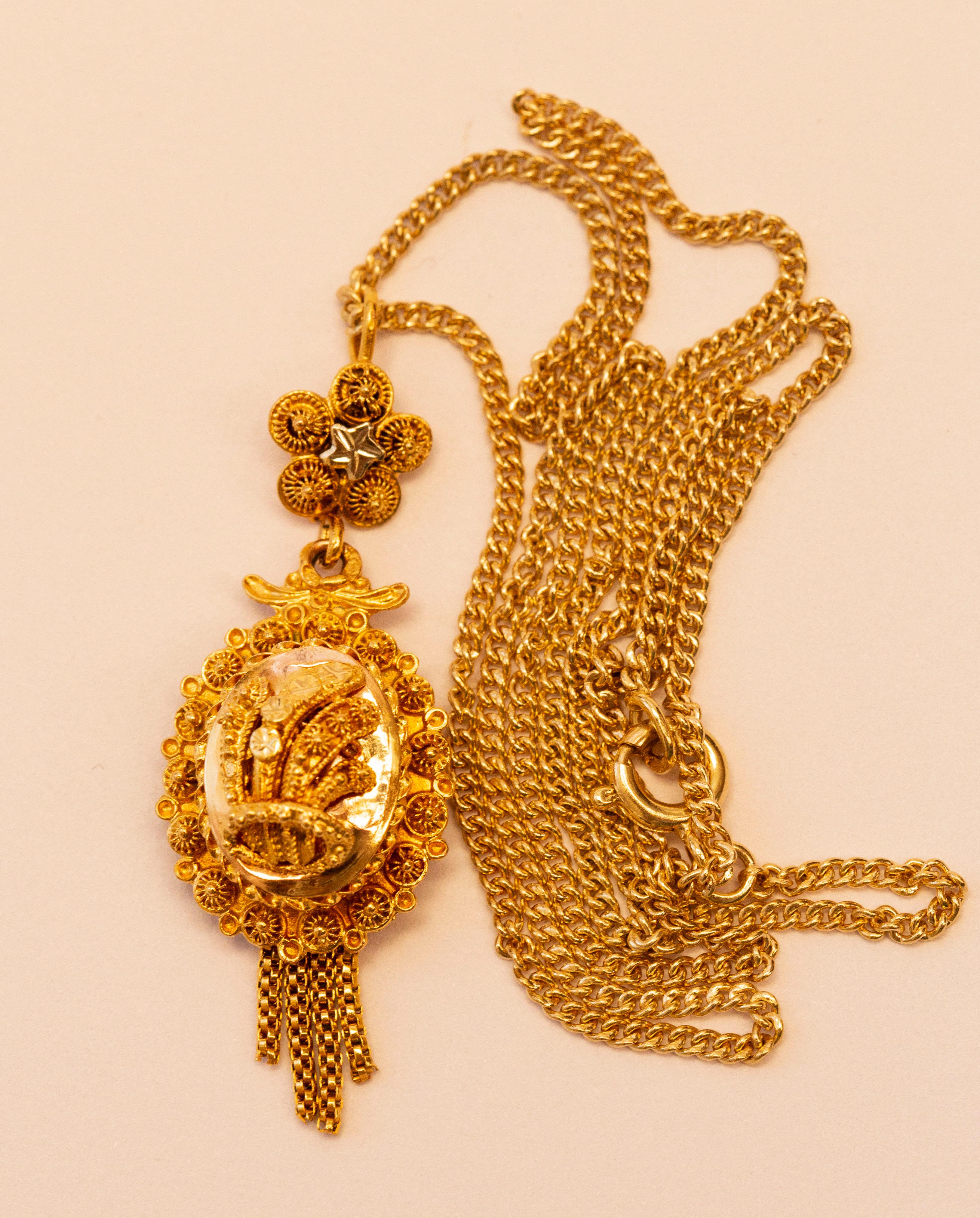 A traditional Dutch 14 karat solid yellow gold pendant on a 14 karat solid yellow gold gourmet link necklace. 
The pendant originates from the early 20th century and it belongs to the traditional regional costume jewelry worn in the Dutch province