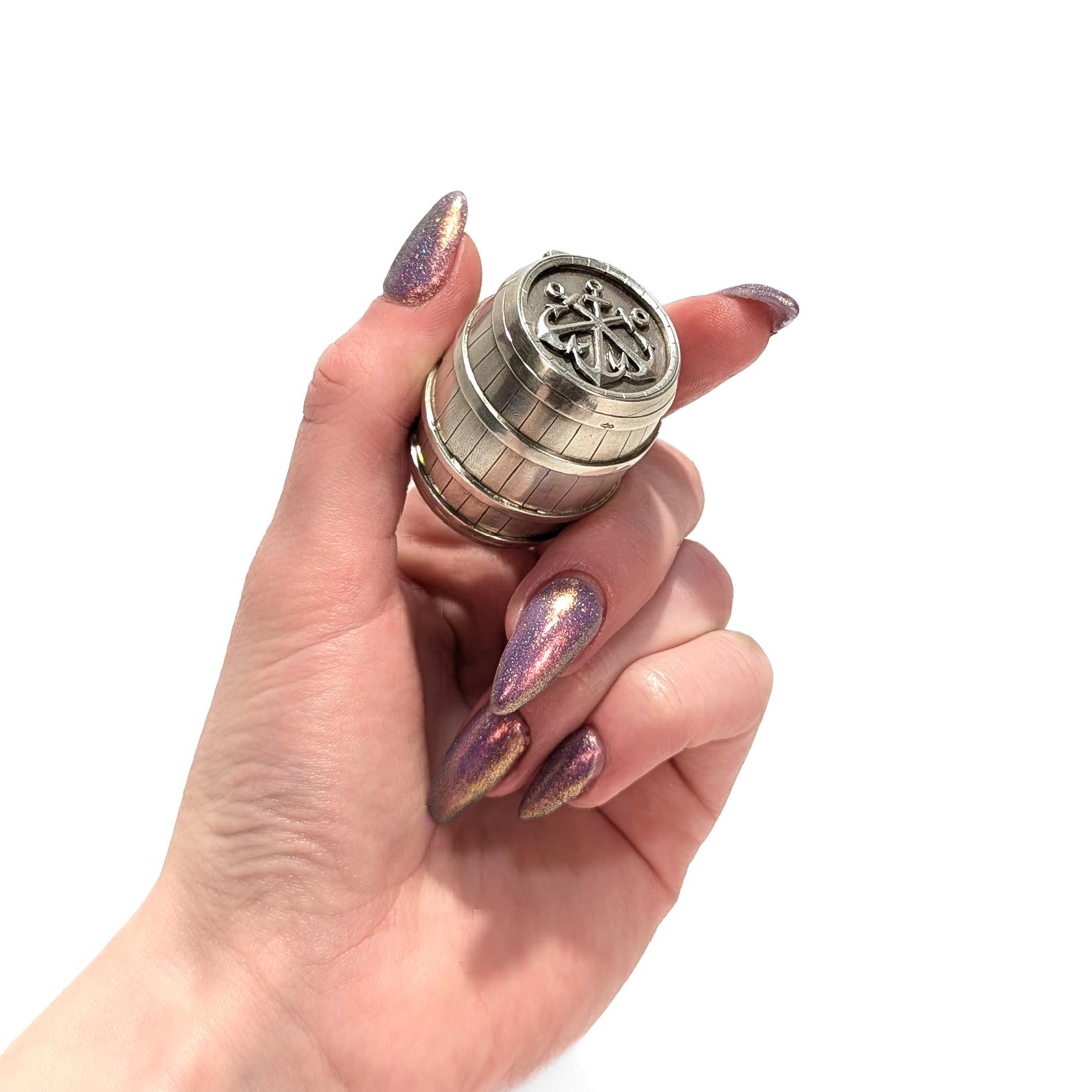 A fine antique, figural Dutch silver matchsafe or vesta.

In .833 silver.

In the form of a barrel with an applied triple anchor device to the lid. (Possibly a reference to Three Anchors bay in South Africa). 

With a ribbed striker surface to the