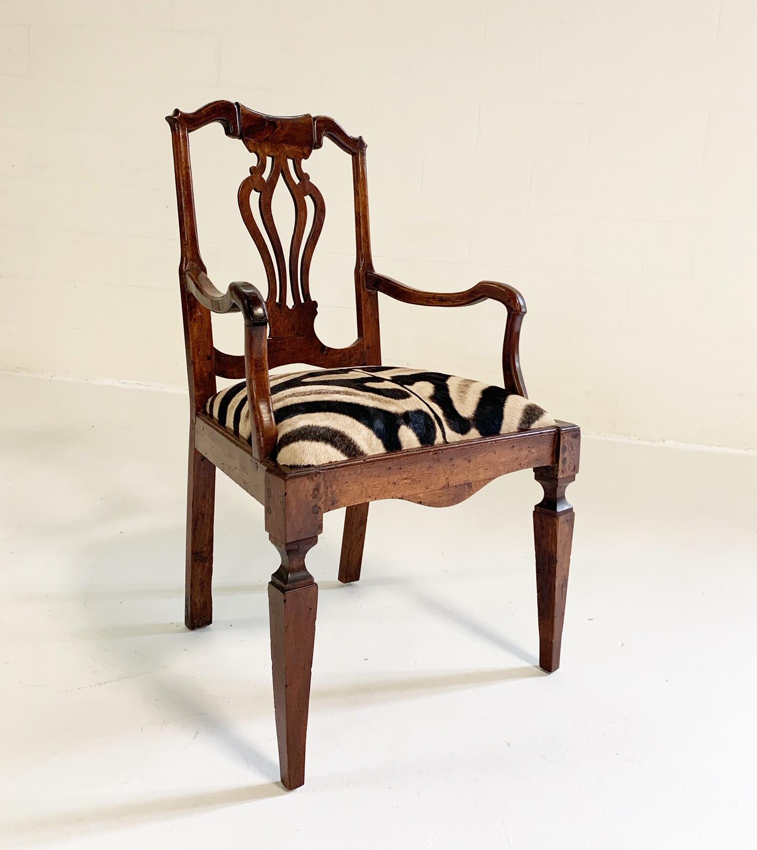 This chair is wonderful. Over 200 years old and it is still in outstanding shape. The Dutch walnut open armchair has a yoke-shaped crest rail over a pierced vase-shaped splat and shepherd's crook arms. The restored zebra hide seat is supported by a
