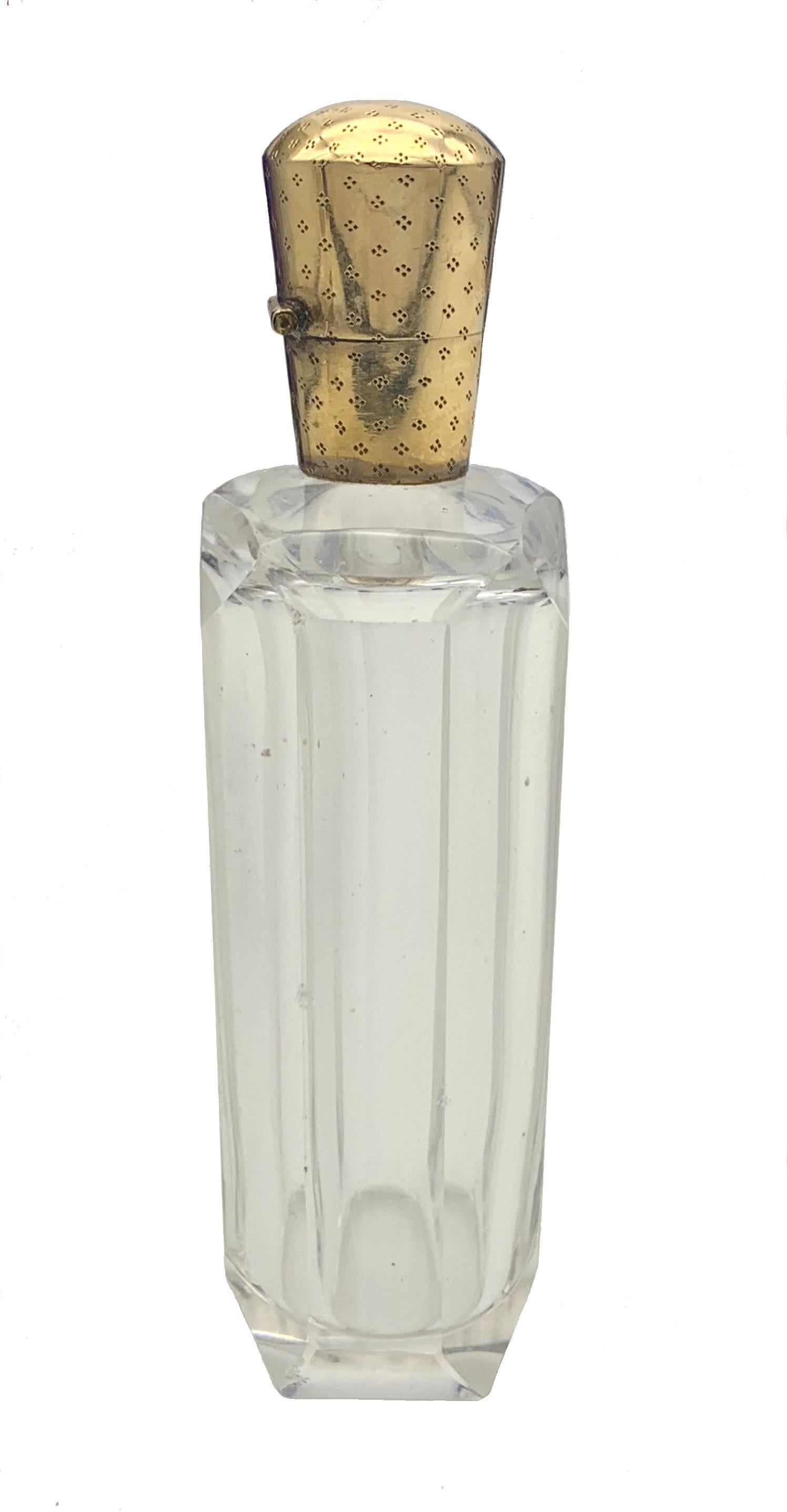 Ce flacon de parfum est en verre taillé à facettes et est muni d'un couvercle en or rouge 14 carats. Les ferrures en or sont décorées d'un motif finement ciselé et les deux côtés du couvercle portent le poinçon néerlandais en forme de feuille de